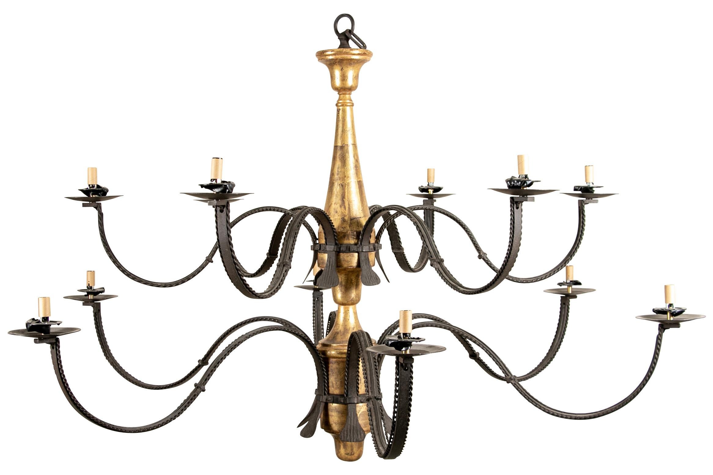 Notable chandelier with handsome form. Large and elegant gilt chandelier in Rustic style. With a gilt tiered metal standard. Two tiers of scrolled black metal arms with twist edges, six lights each tier. 

Good condition with one repair to one