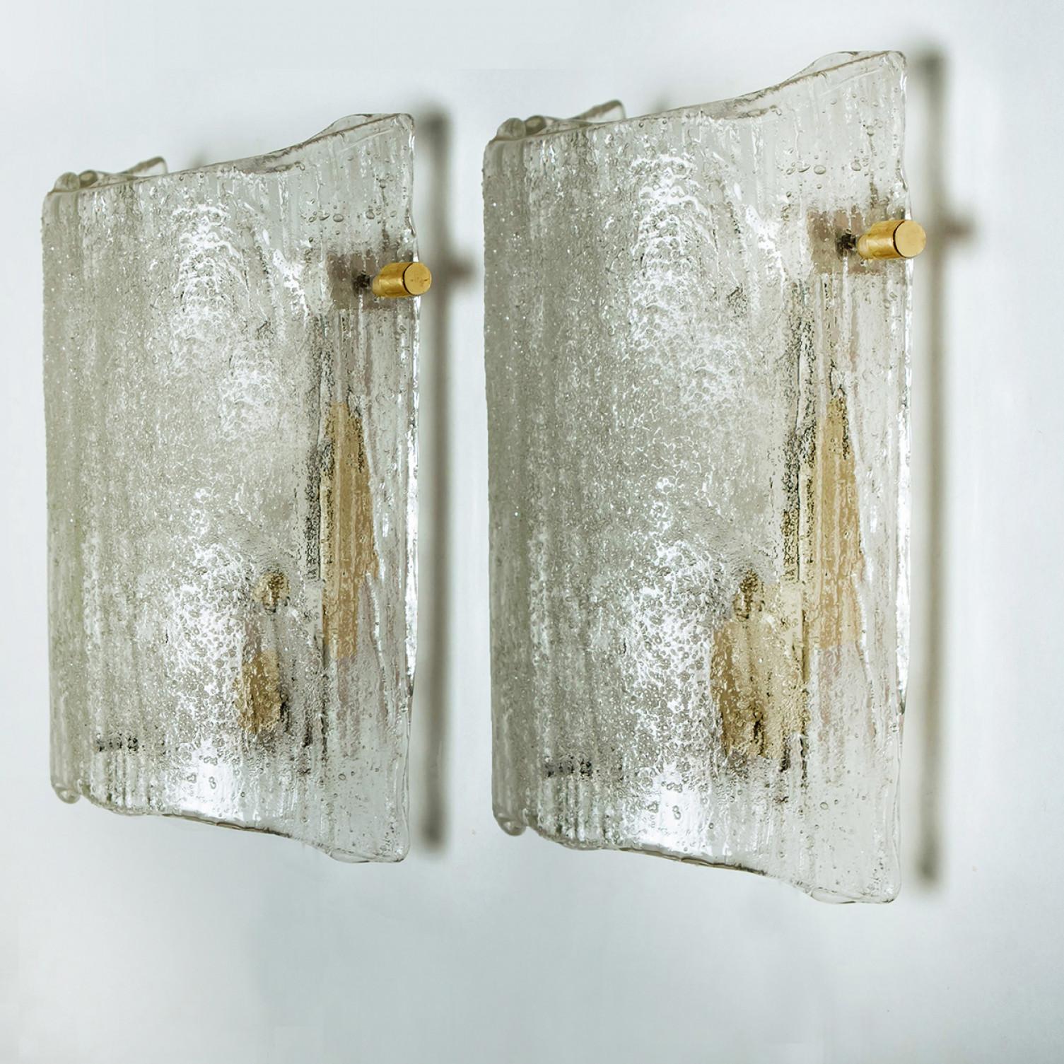 Clean lines to complement all decors. A wonderful high-end J.T. Kalmar wall light fixture with thick textured blown glass giving the piece a heavy ice appearance which refracts the light, filling a room with a soft, warm glow.

The wall sconce has a