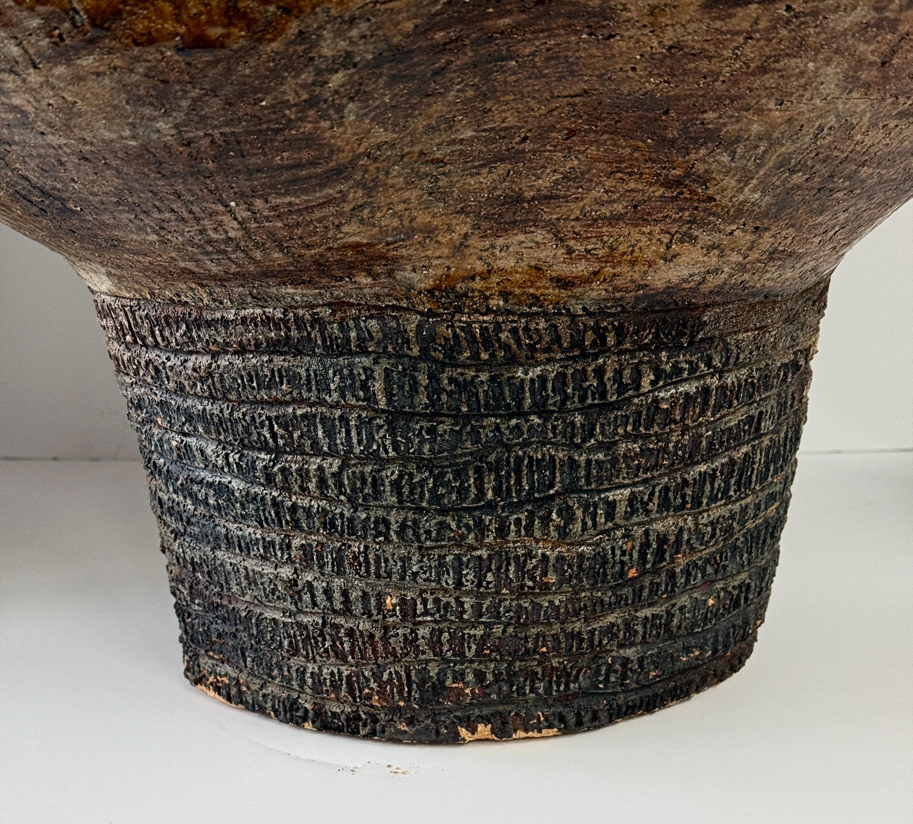 Recipiente macizo de terracota vidriada.  Bellamente ejecutado con azules profundos y marrones verdes en general. La parte inferior está incisa. Está marcada en la base con la inicial y los números 90, que supongo que son la fecha de creación. La