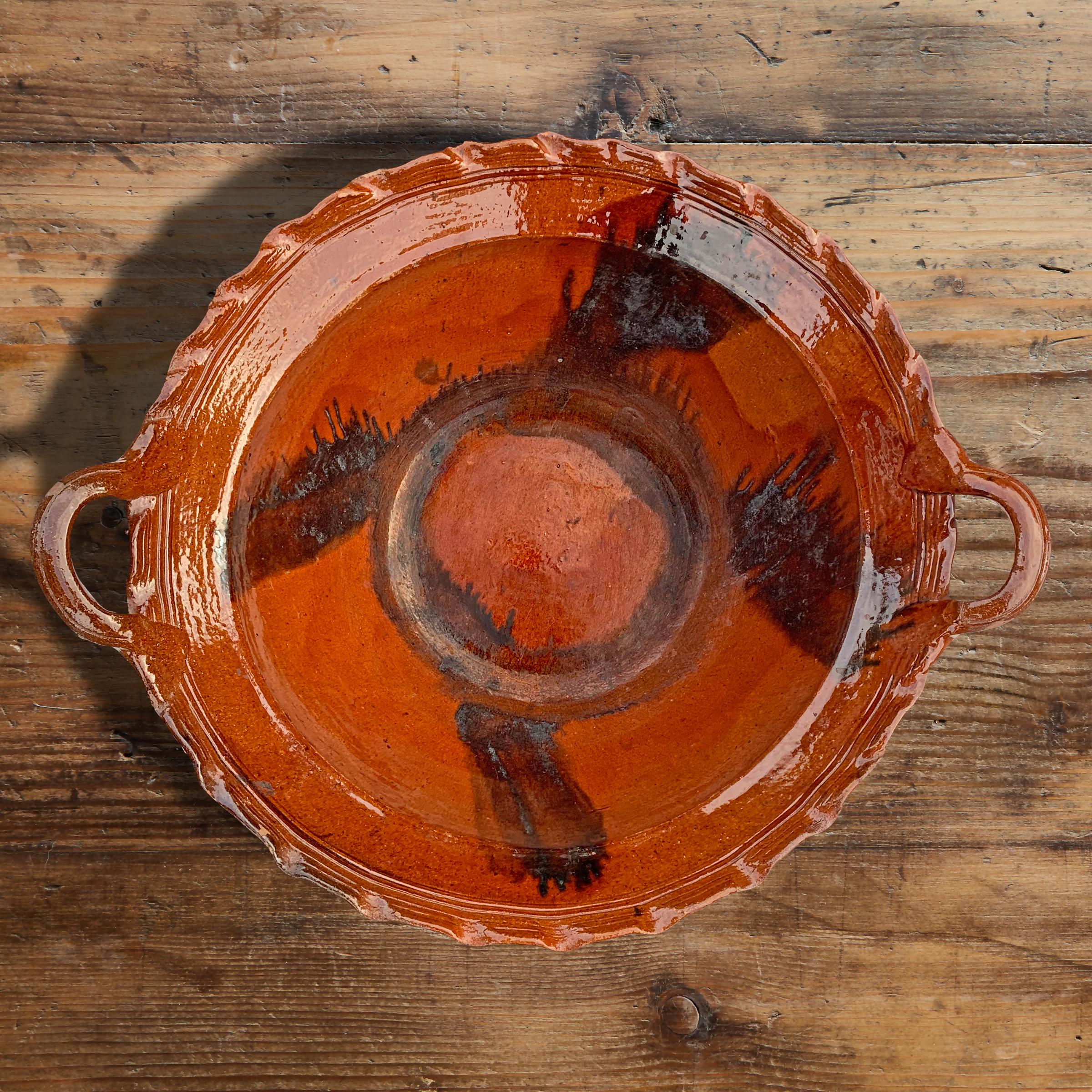 A massive vintage Mexican glazed terracotta bowl with two applied handles and a beautiful drip glazed pattern on the interior. The exterior is unglazed. Perfect for filling with fruit and vegetables on your kitchen island or for serving a salad at