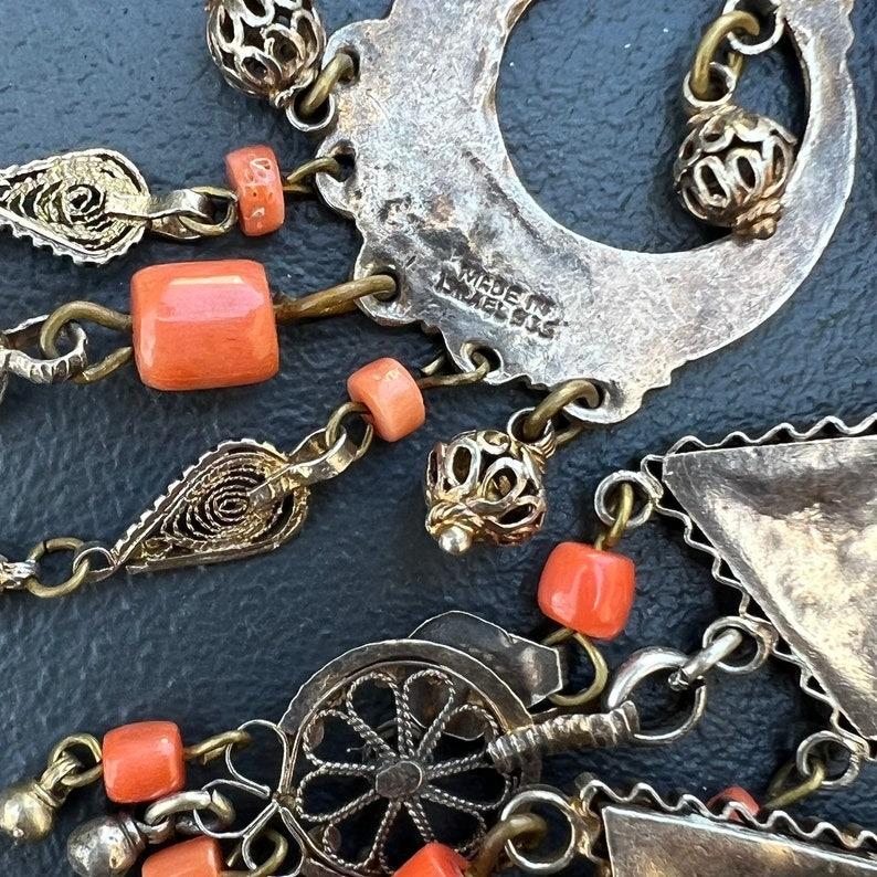 Eine auffällige und aufwändig gearbeitete Latzkette, die von ägyptischen und etruskischen Stilen inspiriert ist. Dieses außergewöhnliche Stück besteht aus vergoldetem Sterlingsilber, das durch echte Korallenperlen und türkisfarbene Akzente