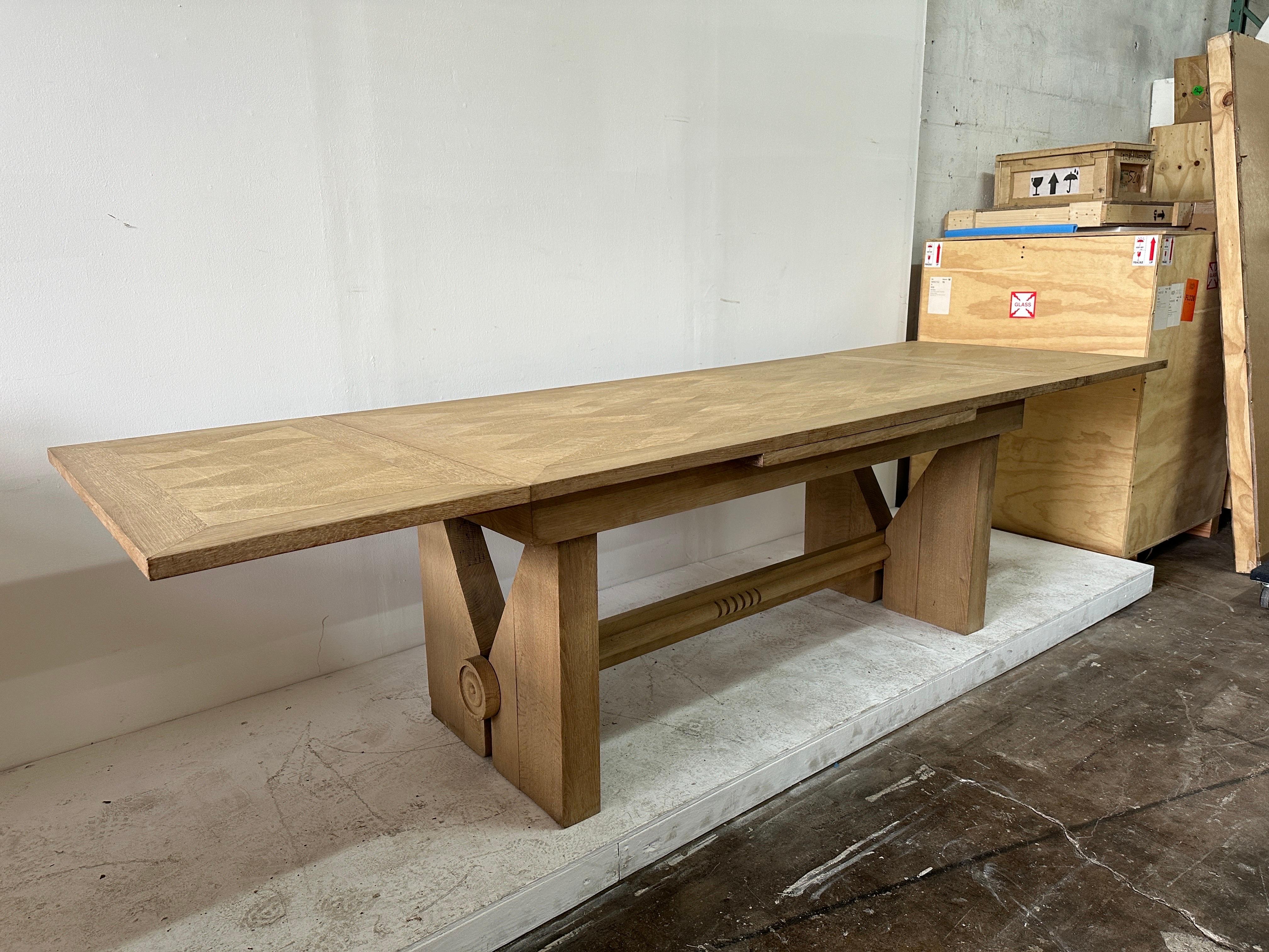 Cette table de salle à manger en bois de chêne blanchi, à la fois vintage et moderne, signée Guillerme et Chambron, peut accueillir 12 personnes lorsqu'elle est déployée et 8 lorsqu'elle est fermée.  Un motif géométrique chic en bois d'arlequin