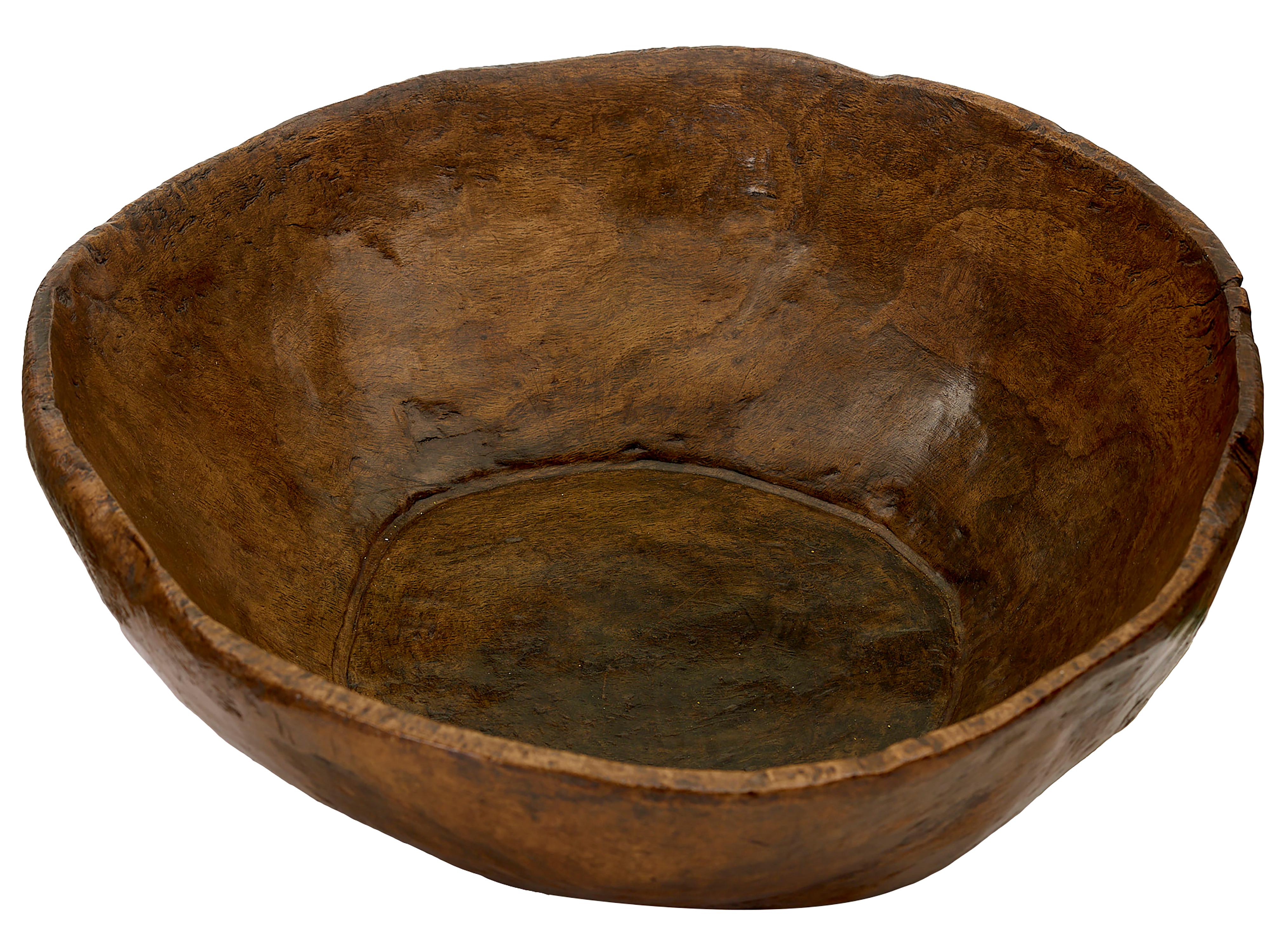 Massive heavy treen bowl. Rough hewn from one piece of walnut. Excellent natural colour. Hand polished rich patina. Mid 19th century. Traces of burning and wear underneath from stone hearth. Dia. 64cm, h 23cm.