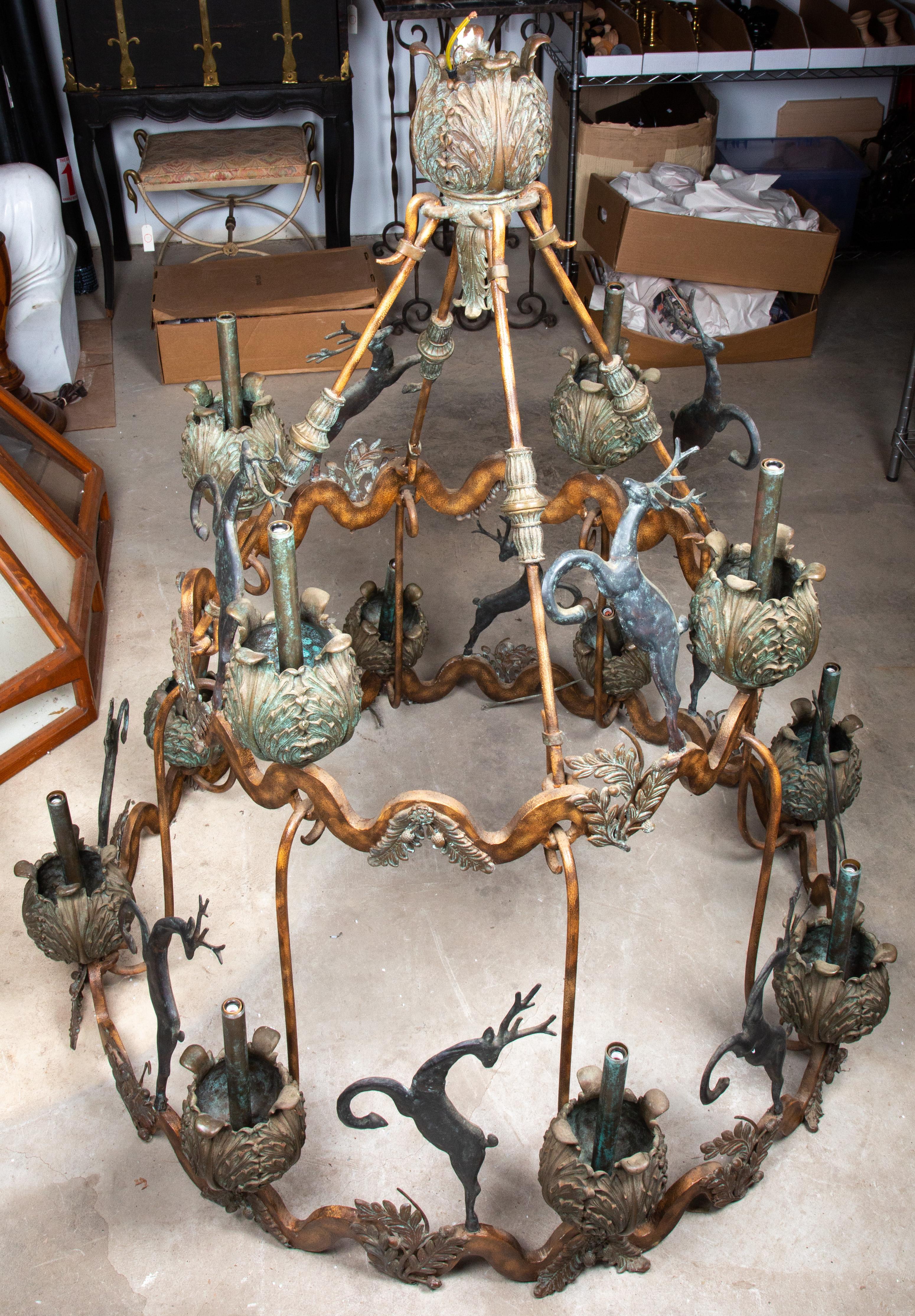 A monumental early 20th century continental iron and bronze chandelier with leaping stags in silhouette and different fauna.
