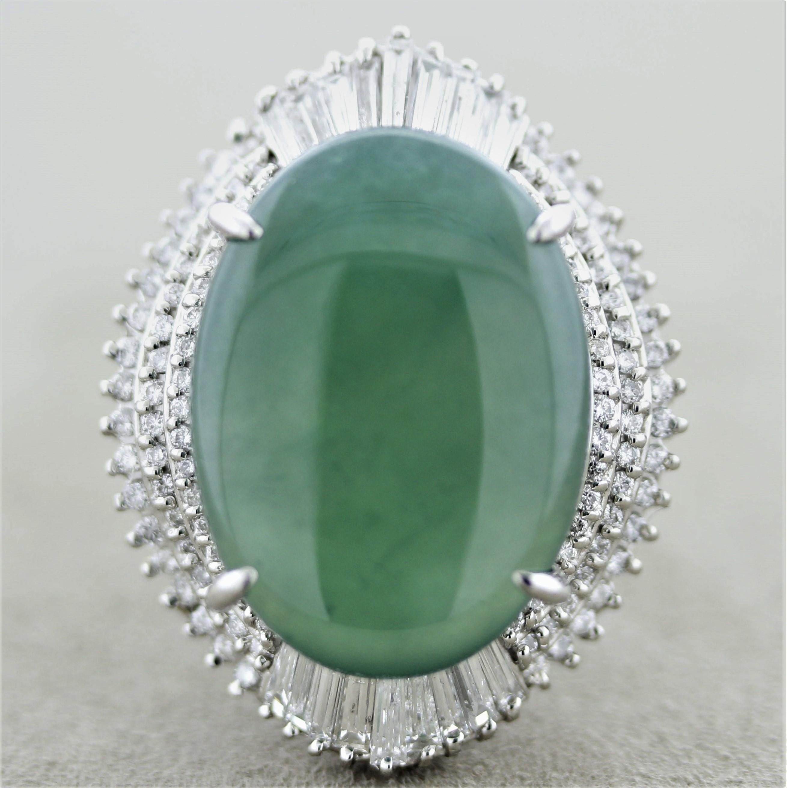 A substantial and bold ring featuring a natural 23.22 carat jadeite jade. It has an even green color and is semi-translucent allowing light to emanate from the stone. It is accented by 3.46 carats of round and baguette-cut diamonds set in a stylish