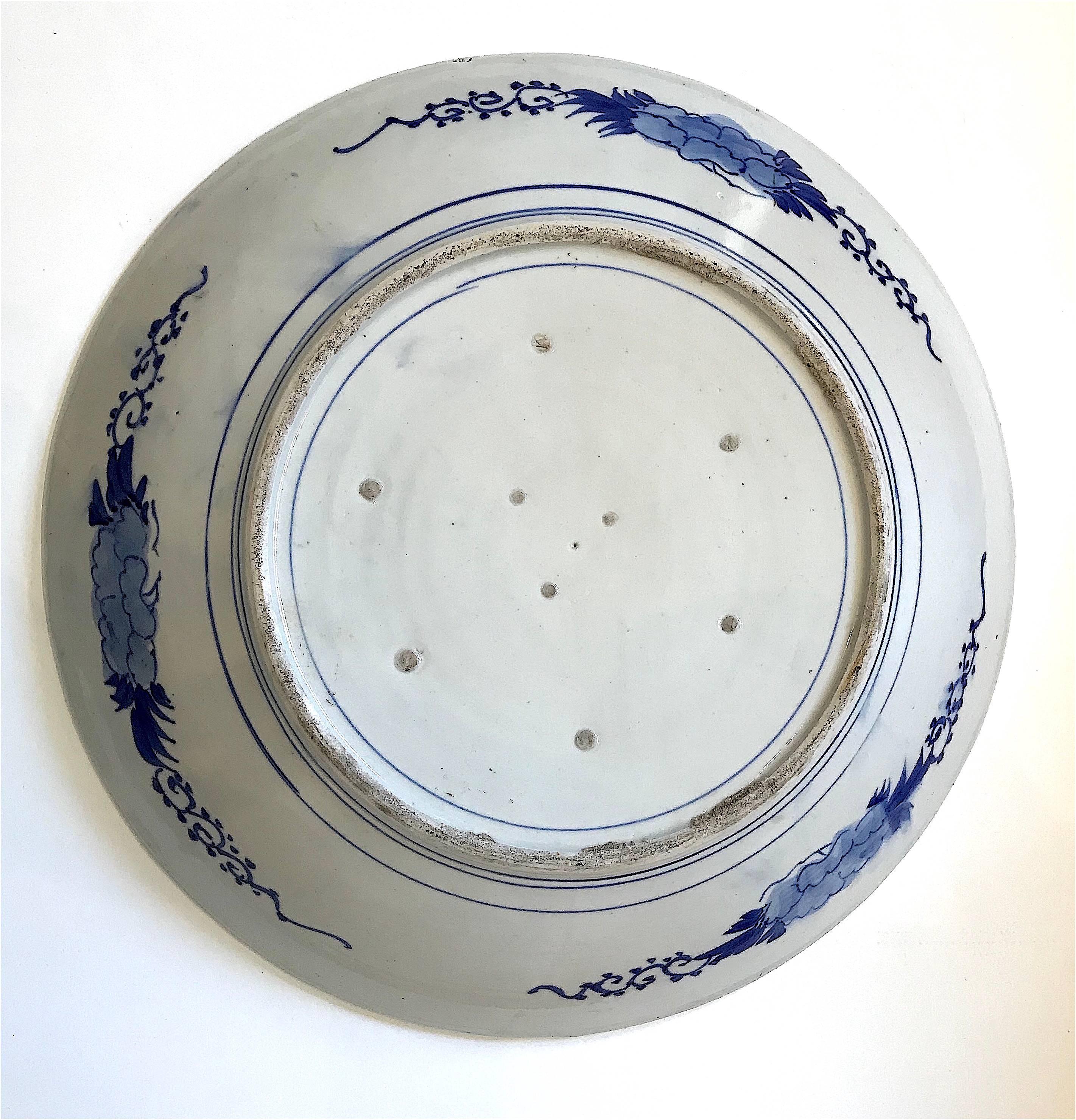 Impressive example of 19th century Japanese porcelain art, this massive and very beautiful charger features an evocative rendition of the 'koi' or carp, with its symbolic reference to good luck and good fortune, in blue on white. In excellent