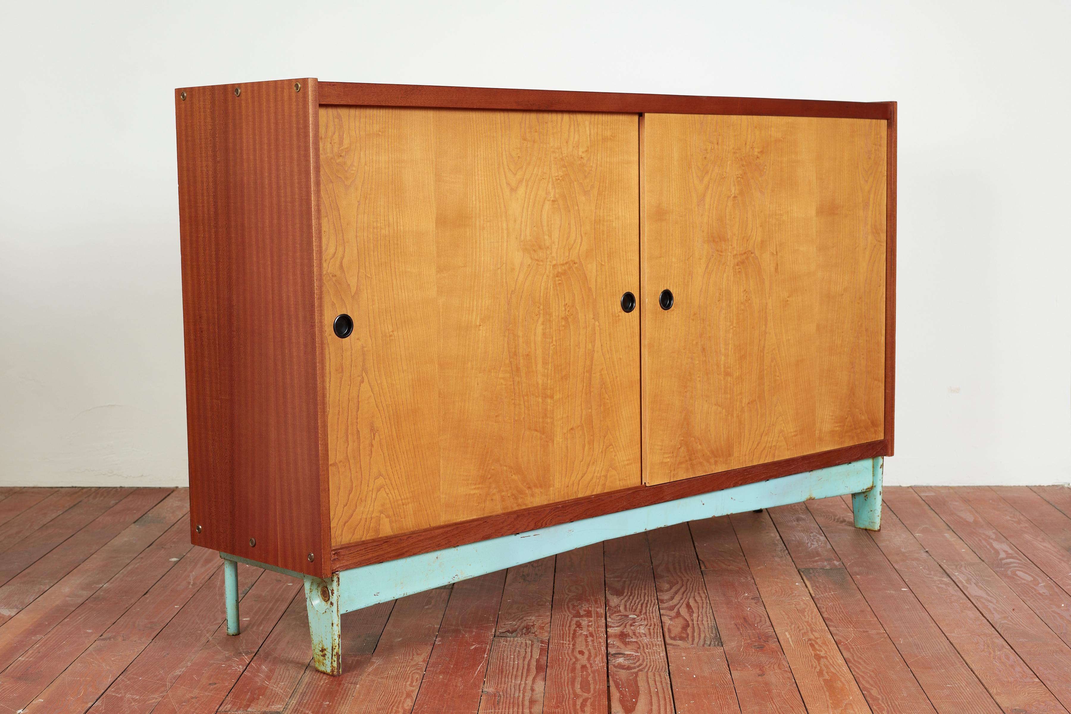 Large sized cabinet in the style of Jean Prouve with industrial mint green steel base with fantastic patina and shape. 

Wonderfully constructed of cherry wood and oak 

Bypassing sliding doors.

Matching painted shelving 

Beautiful patina