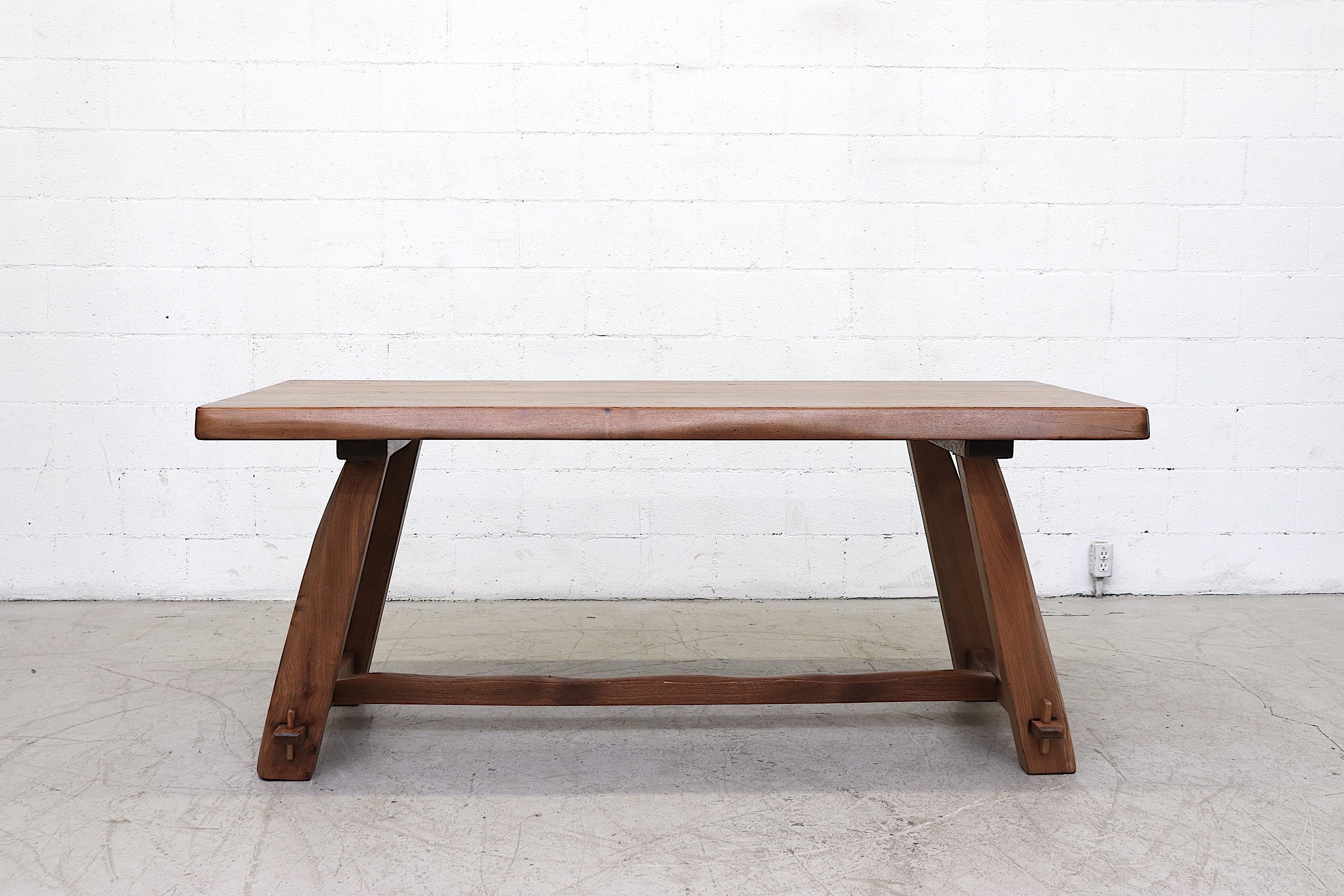 Beautiful live edge pecan dining table with trestle and wood pegs. Nicely refinished with impressive grain. Comfortably seats 6 and radiates character and style. Original condition with minimal wear. Similar tables available listed separately.