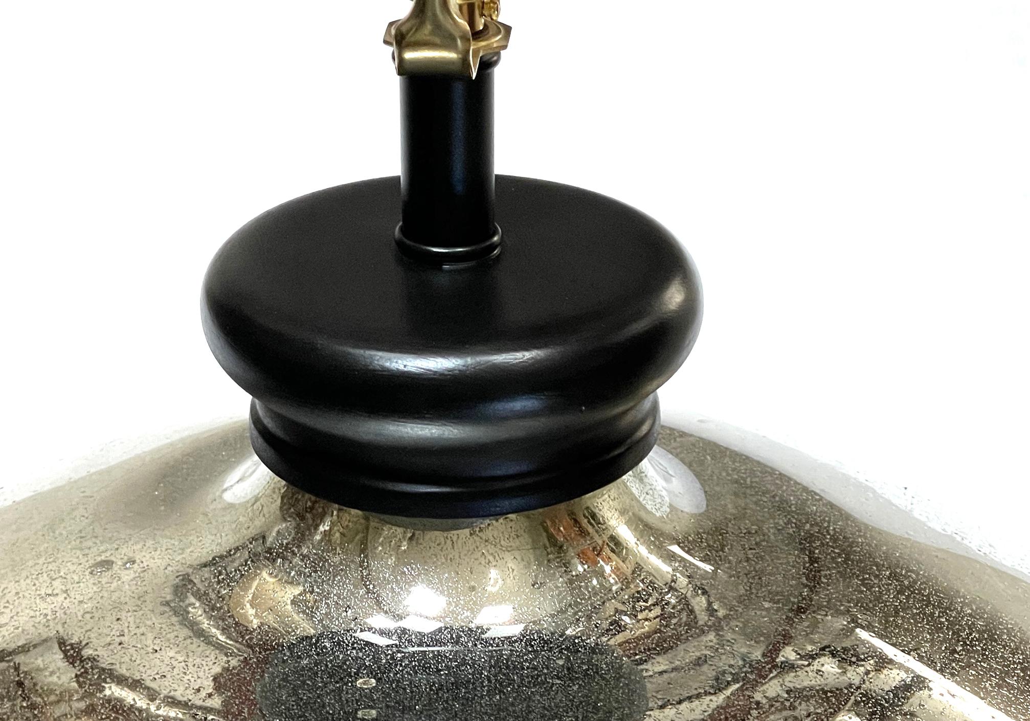 of impressive scale, the orb-form lamp of mercury glass fitted with an ebonized wooden cap and base
