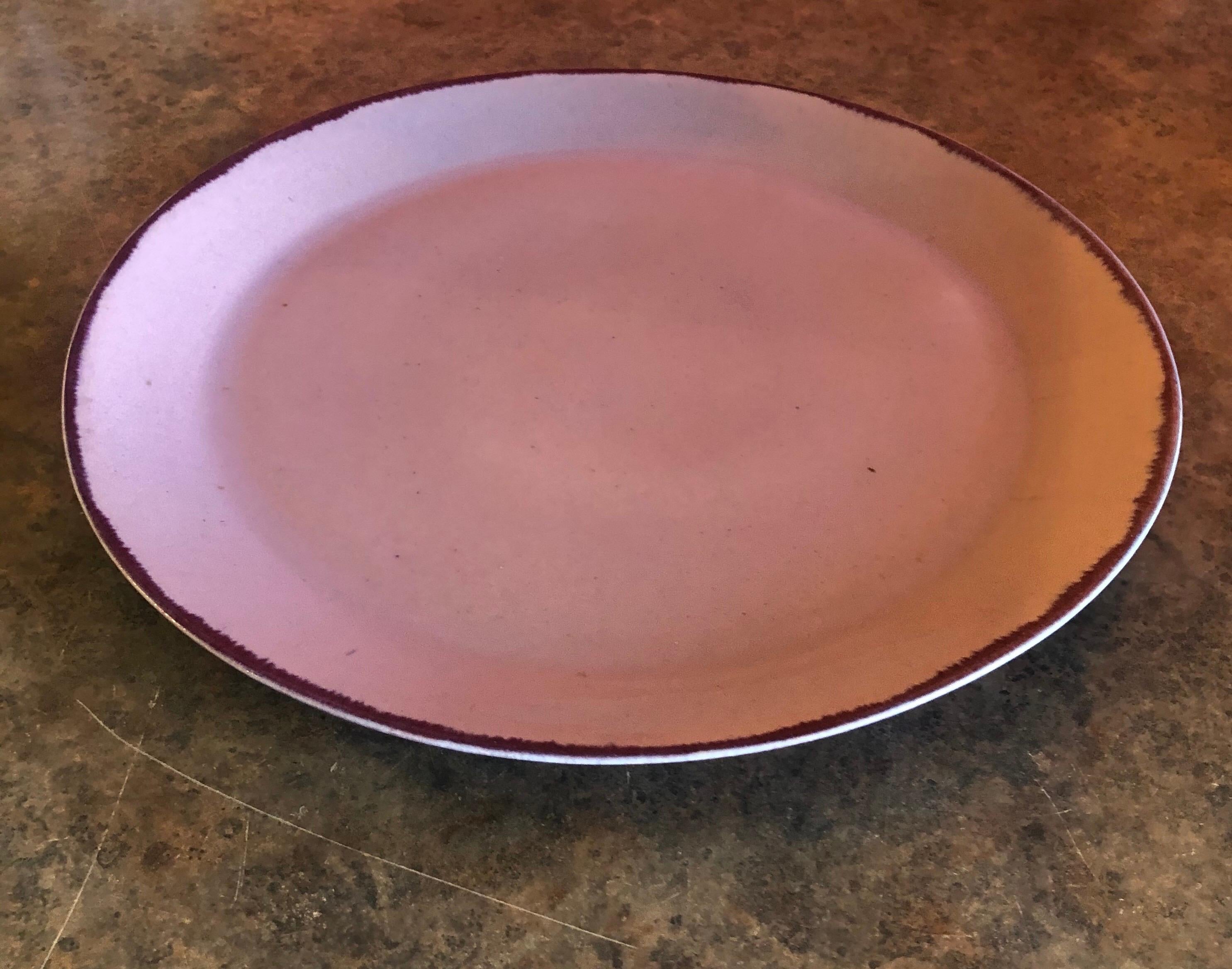 Massive midcentury platter / serving tray by Winfield Pottery of California, circa 1950s. The piece is a light pinkish-purple in color with a dark cabernet outer rim and measures 17