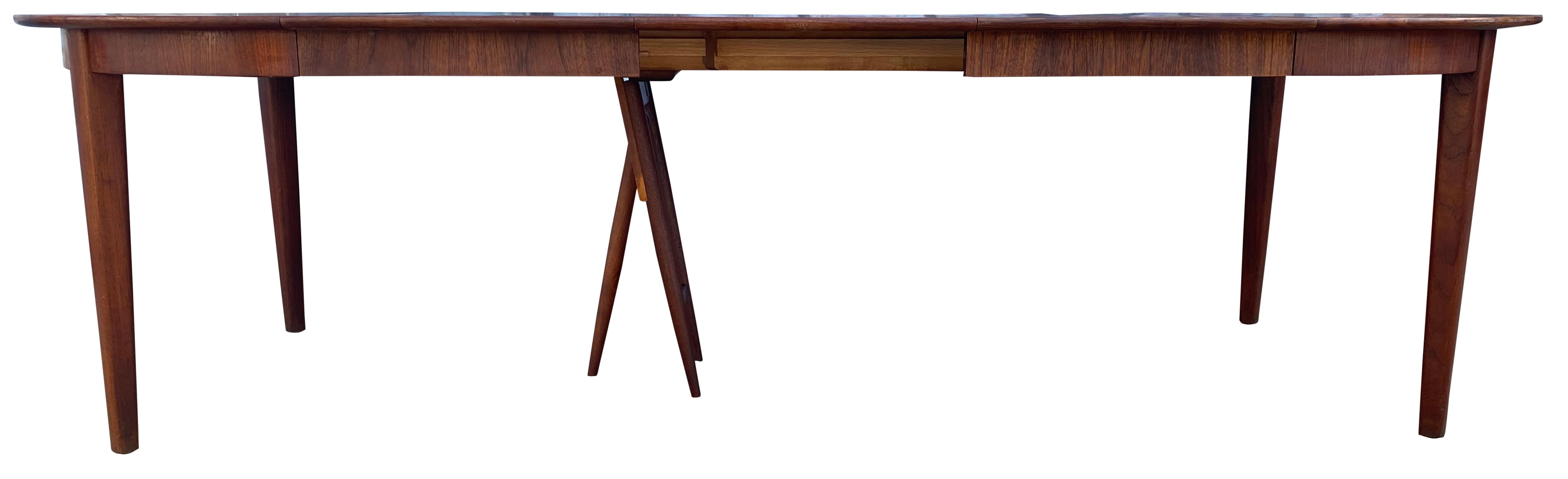 Massive midcentury teck Danish extension dining table #32 with (3) leaves by Henning Kjærnulf. Cette table est de très haute qualité, construite à la main par des fabricants de meubles danois et fabriquée au Danemark. Étiqueté D32, chaque pied est