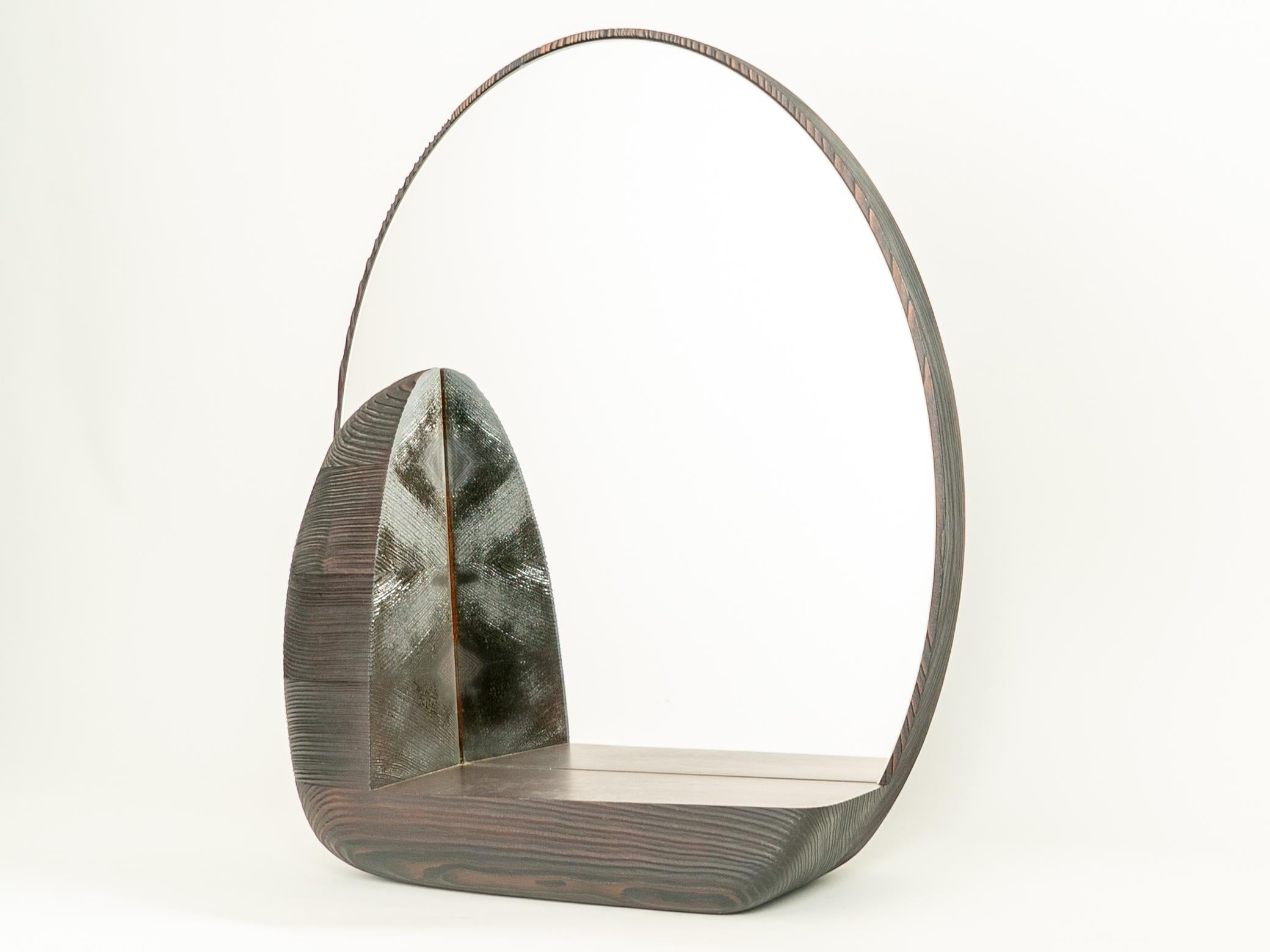 Massive is a mirror like a hollowed-out raw mass, the delicate, fragile mirror housed in a raw shell and offering a strong contrast to sight and touch.The curvature, hollowed out to create a console, makes this mirror the ideal accomplice for an