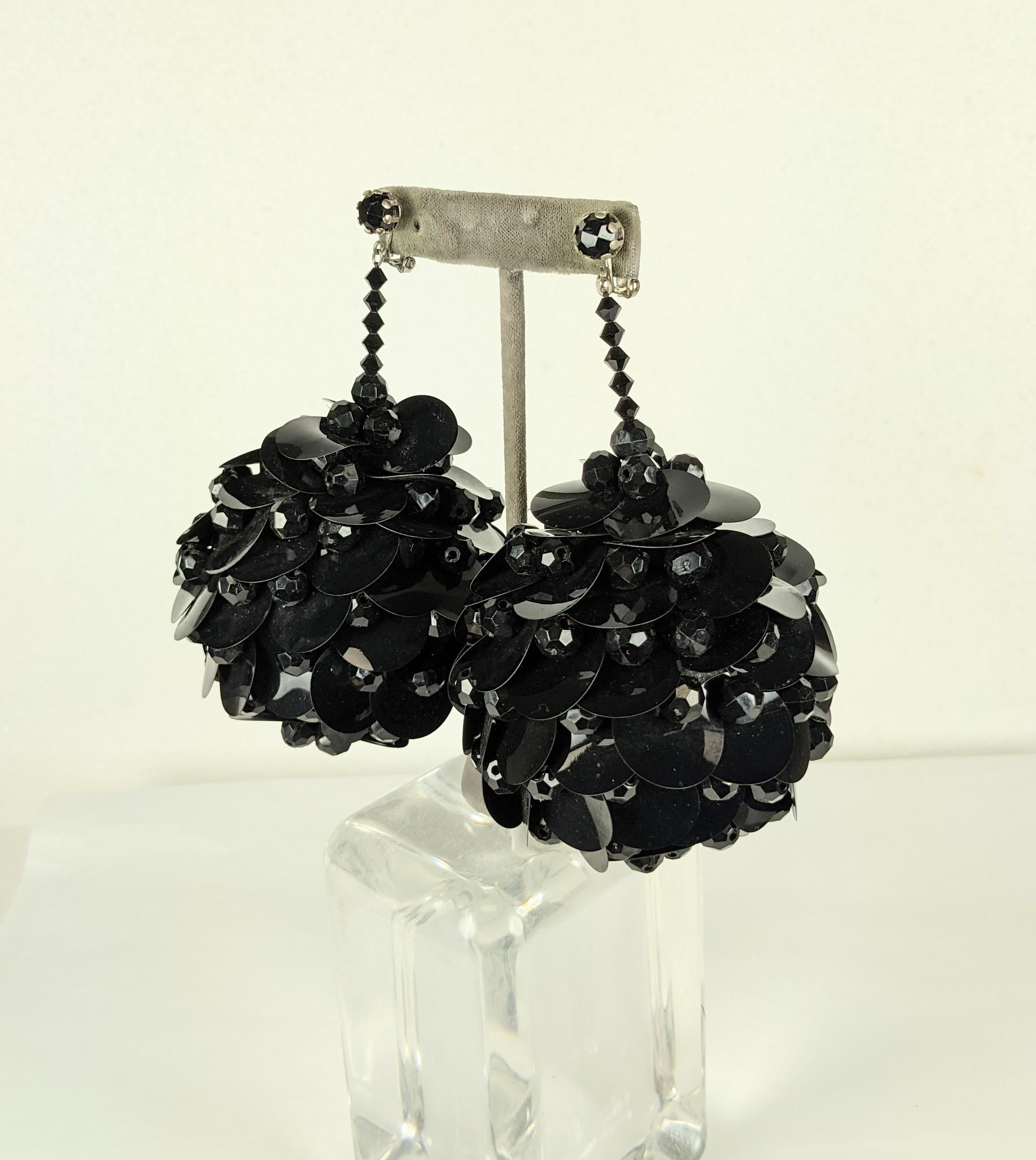 Channel your inner Twiggy with these Massive Mod Sequin Ball Earrings from the 1960's.  Huge spheres are hand sewn with resin jet beads and black circular paillettes resembling round pine cones, likely on a foam base. 
Clip back fittings. Not