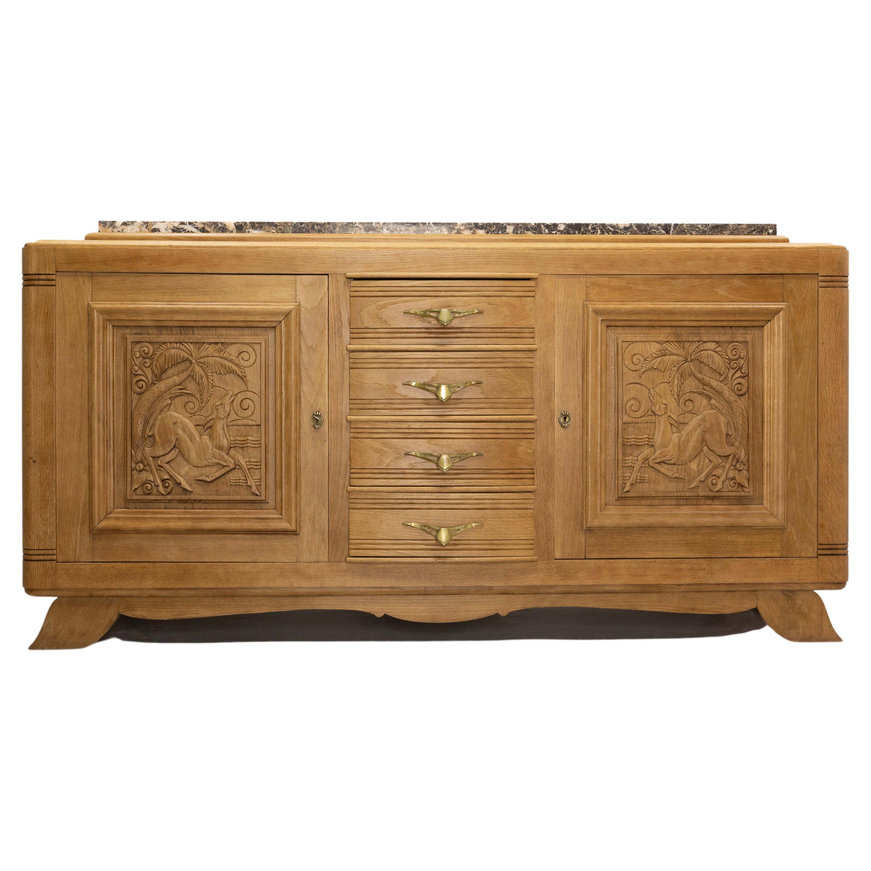Mid-century sideboard French credenza buffet, circa 1940.
Four drawers and two cabinets with a carved antelope in and exotic decor on each door.
Marble top, and solid oak, 
Very good condition, this cabinet has been completely stripped and the
