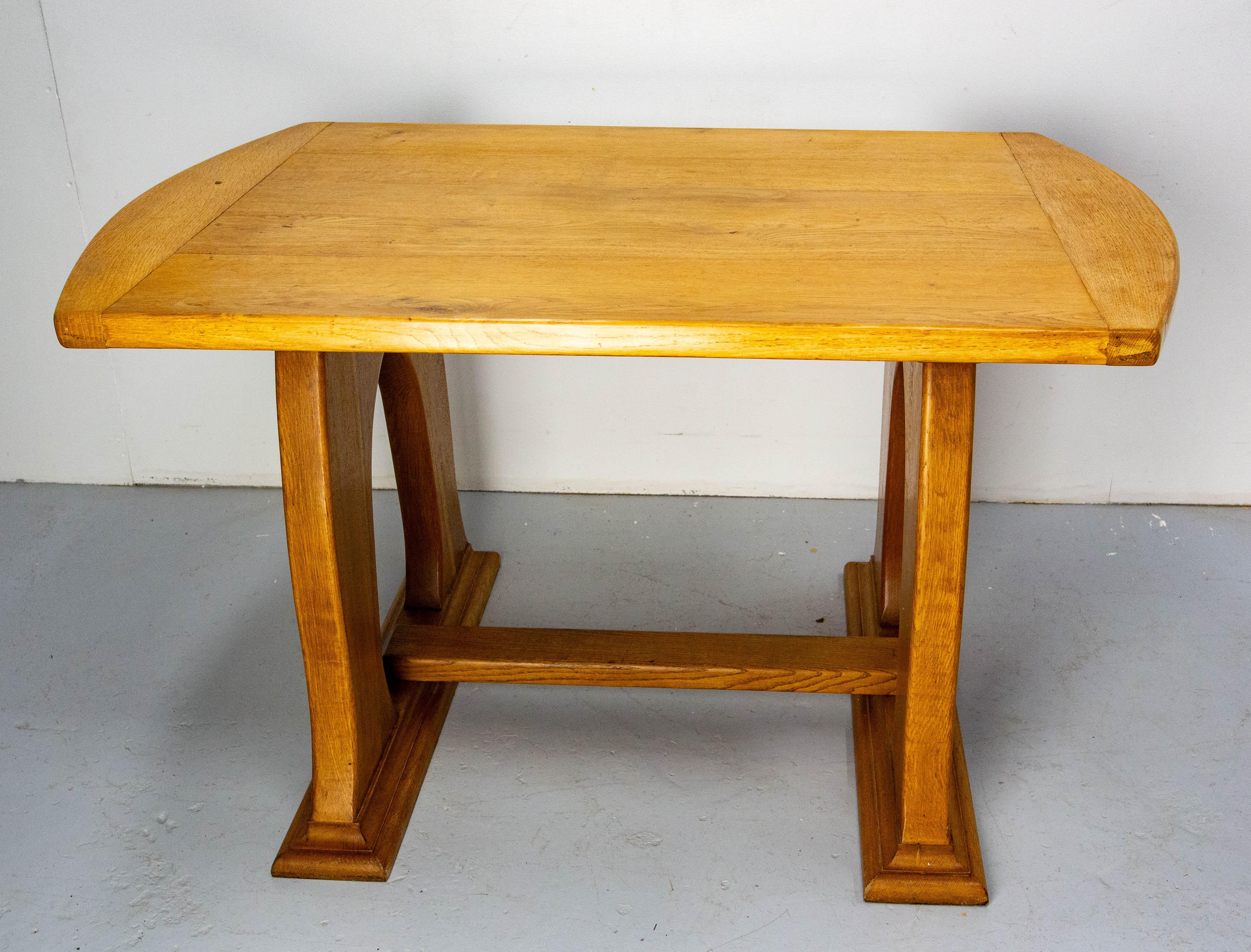 Oak table made circa 1960.

The table shape is inspired by the lines of art nouveau. This gives to this item an elegant and rare style. 
As you can see on the last photo, a piece of the table has been repaired under the table top before our