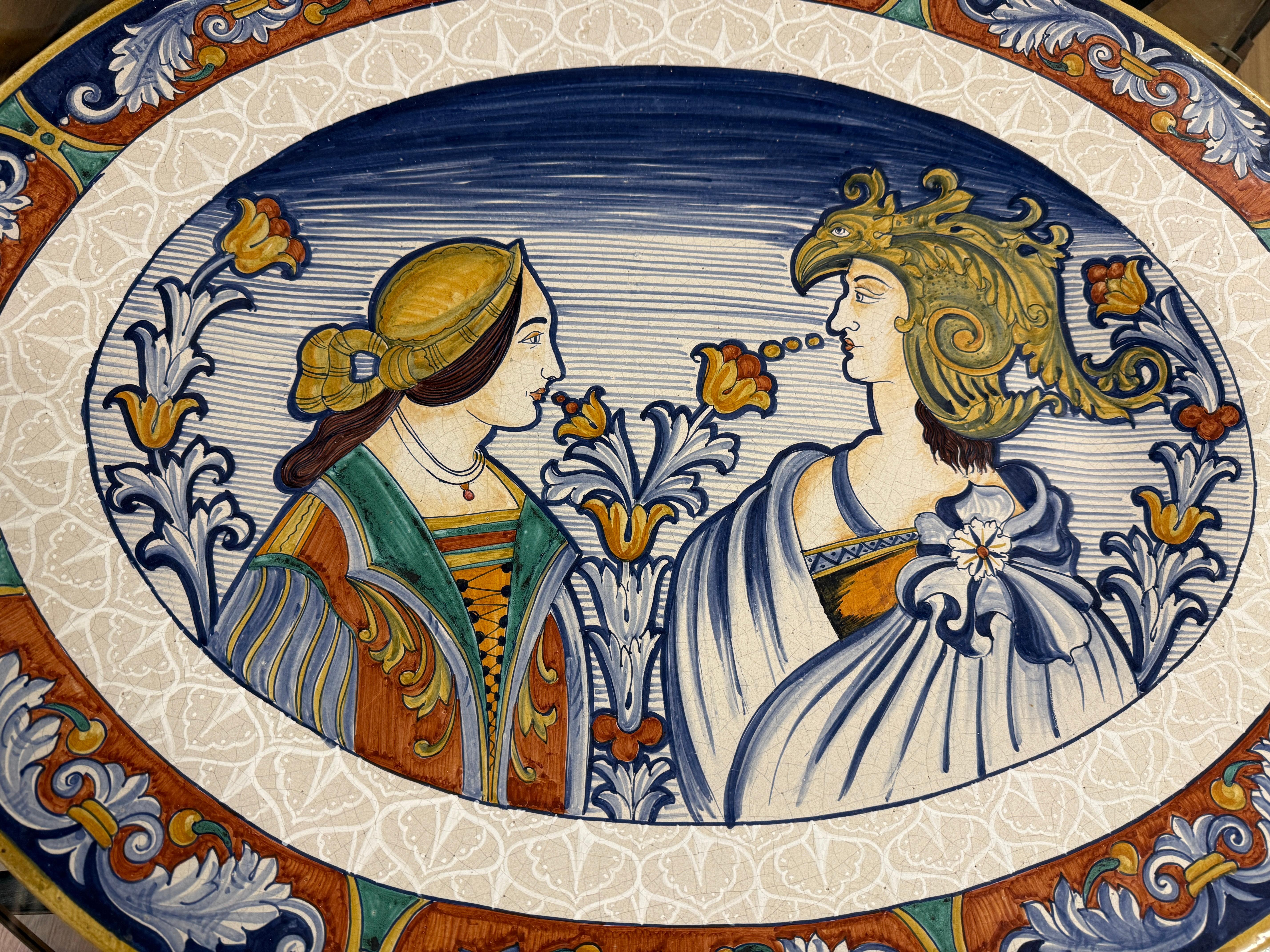Un bel caricatore o piatto da portata in maiolica massiccia dell'Antica Deruta. È uno dei piatti più grandi che abbiamo visto, con i suoi 33,5 pollici di diametro. È firmato sul retro. Raffigura alcuni personaggi allegorici, probabilmente Romeo e