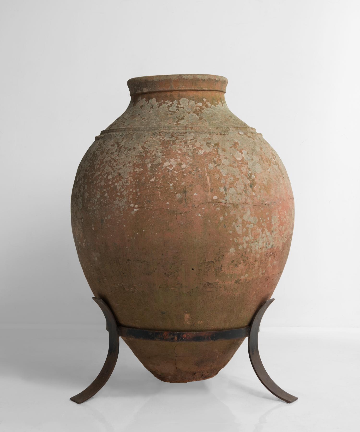 Massive olive oil jar on metal stand, Italy, circa 1910.

Exquisite, large form with wonderful patina that sits in a metal stand.