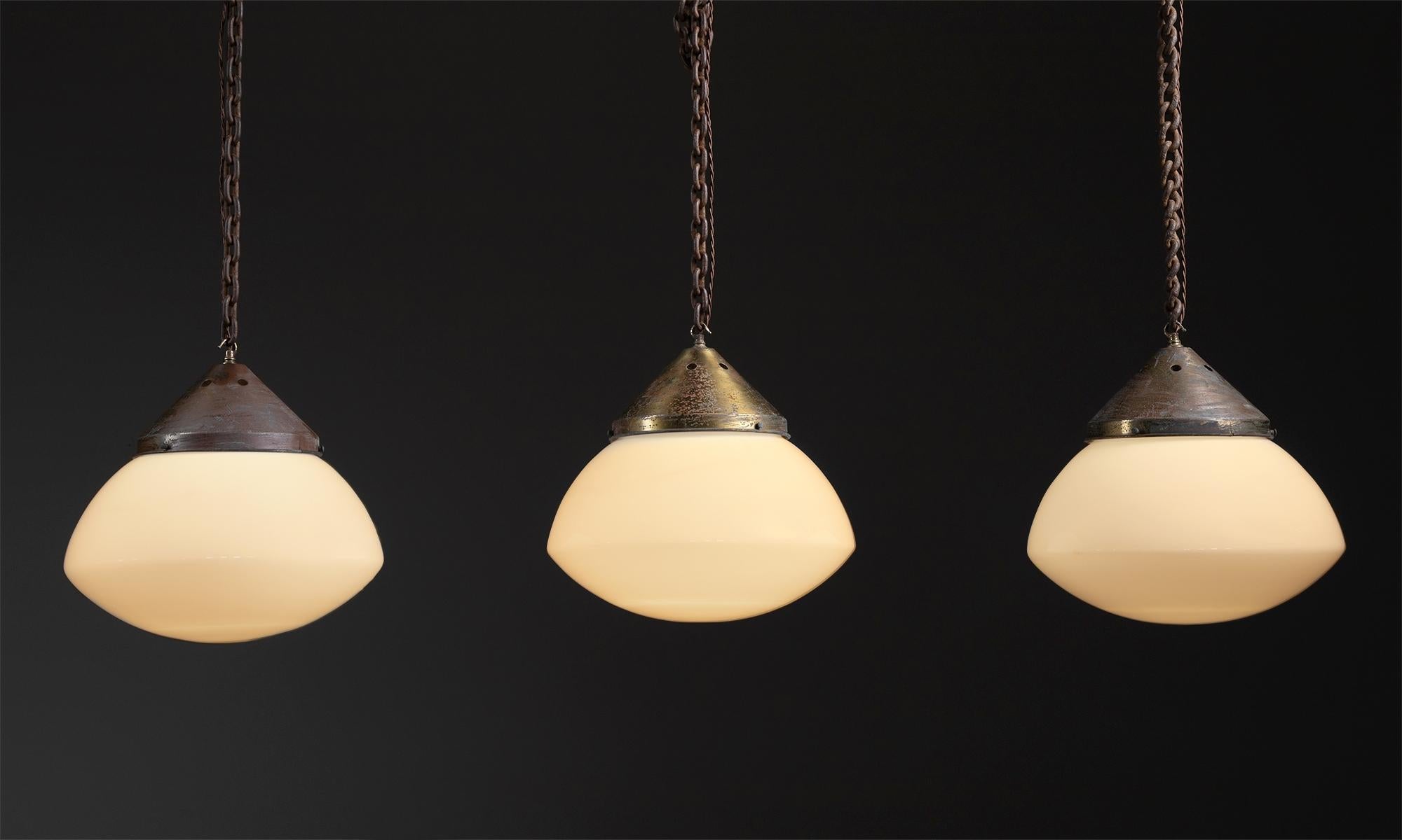 Massive opaline pendants.

England, circa 1930.

Ovaloid glass shade with original brass gallery. *Chain and Canopy not Included*

Measures: 17”diameter x 17.5”height.