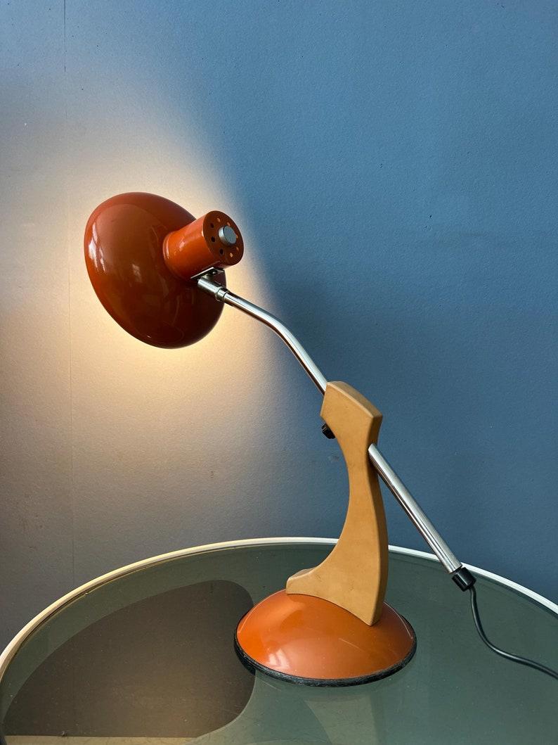 Massive orangefarbene Space-Age-Schreibtischlampe mit verstellbarem Arm im Stil der Fase Madrid. Der Arm kann verstellt werden und auch der Schirm selbst kann neu positioniert werden. Die Lampe benötigt eine E27/26 (Standard)-Glühbirne und hat