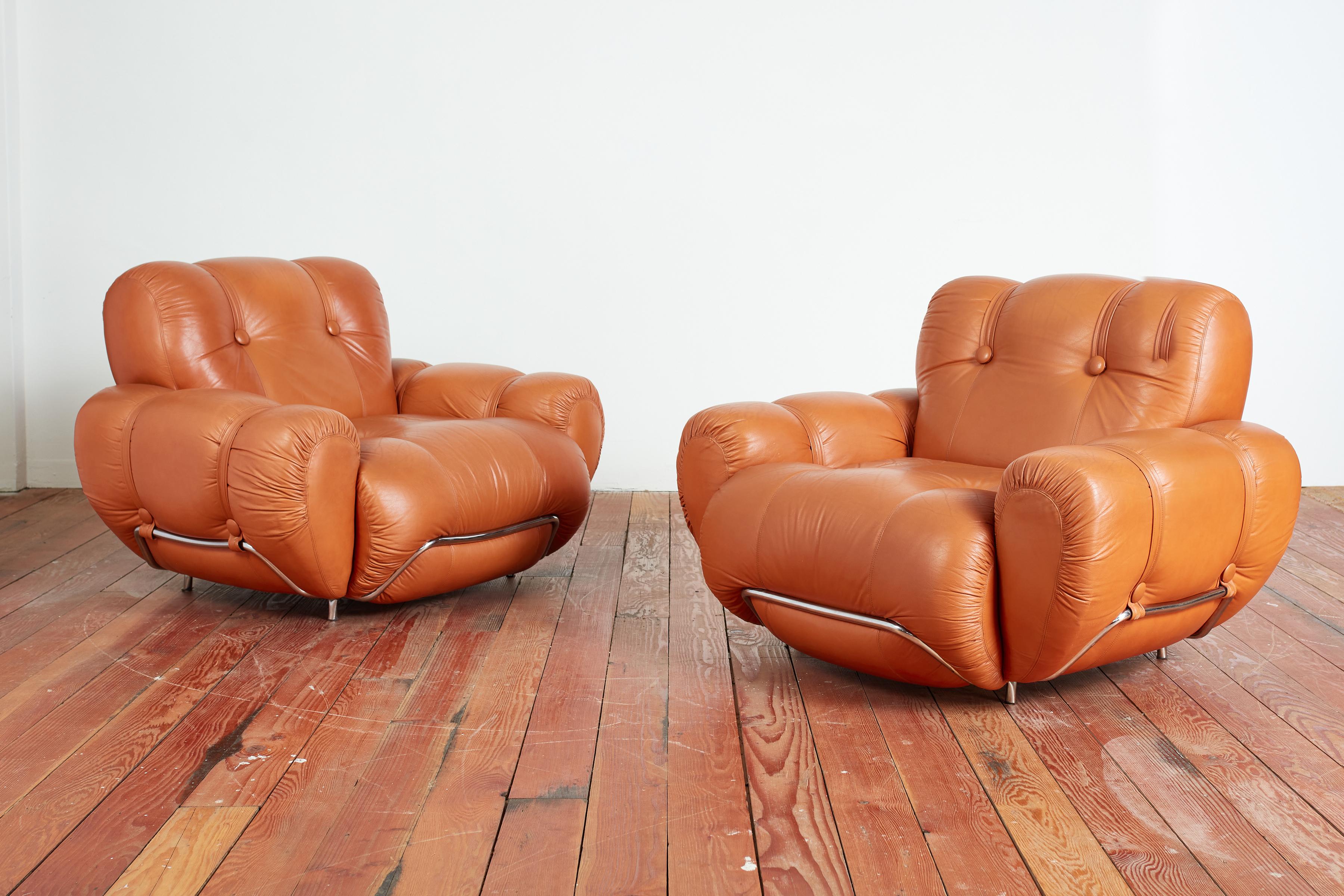Huge pair of Italian leather lounge chairs with bulbous design and wonderful curves. 
Chrome detail throughout with tufted leather cushions. 
Italy, 1970's 
