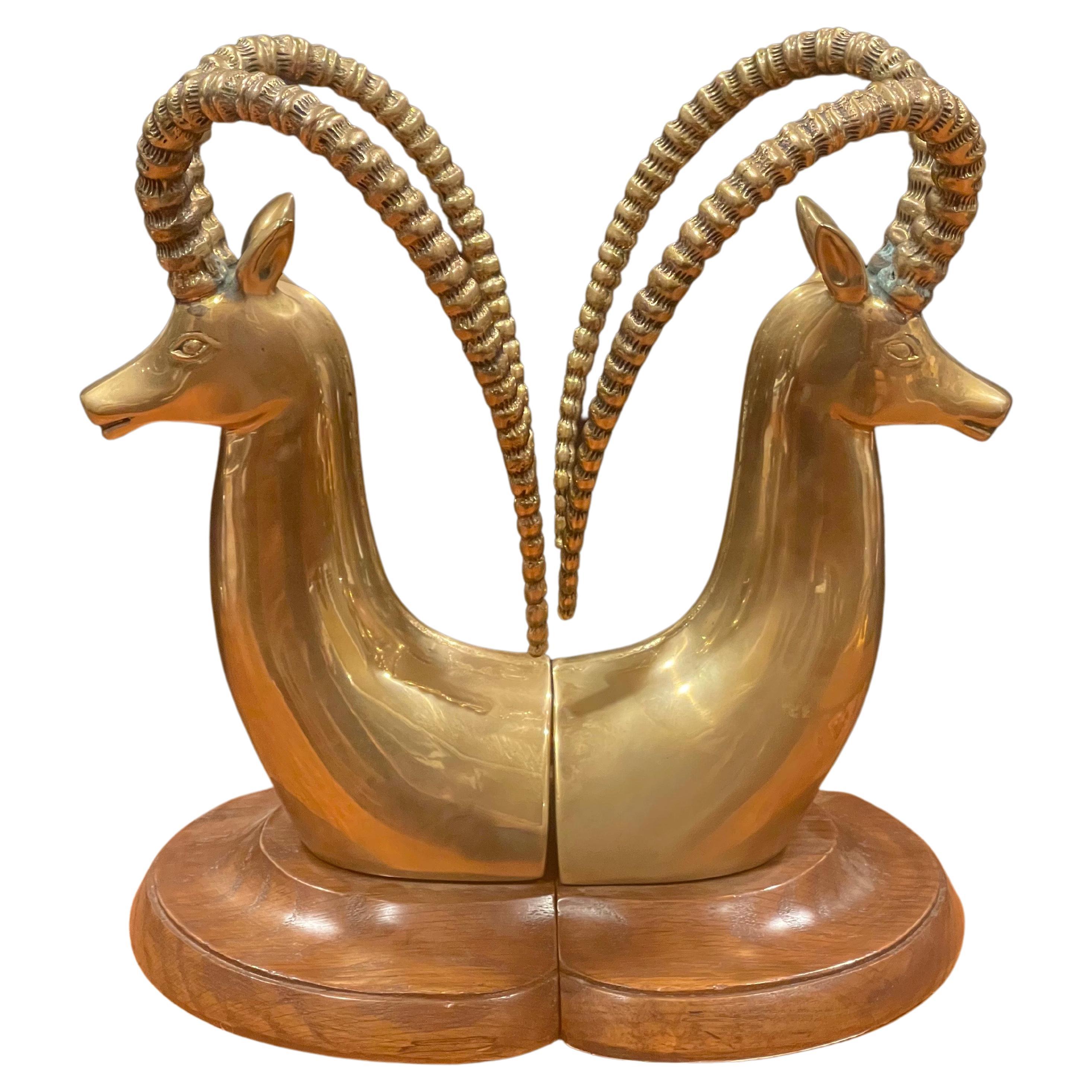 A massive pair of brass rams head bookends on walnut bases by Sarreid, circa 1970s. The bookends, which were made in Spain, are in very good condition and have a great look. They measure 10.5