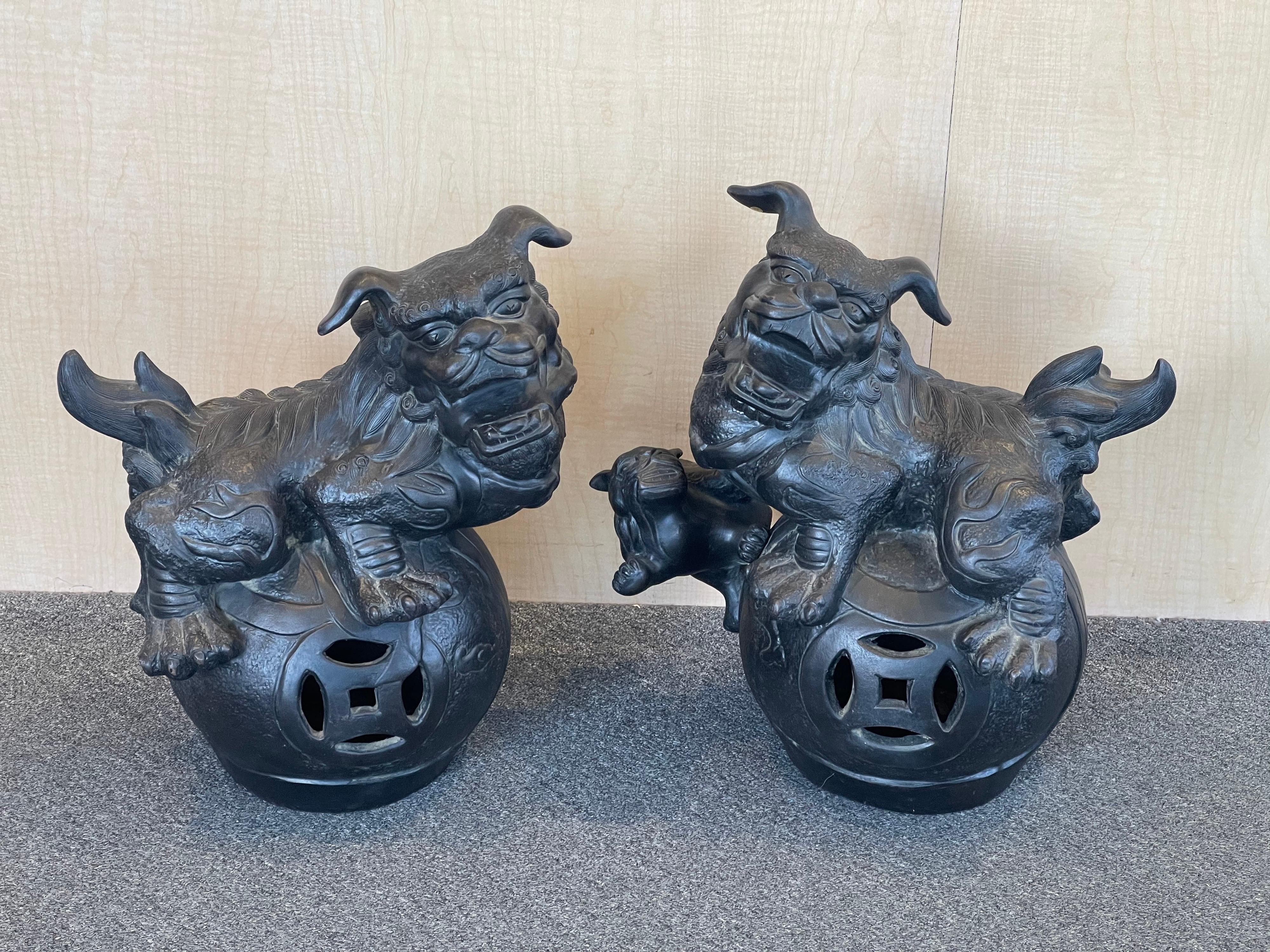 Incredible, massive pair of ebonized pottery Chinese foo dogs, circa 1950s. This unusual pair are finely crafted with amazing detail sitting on xiu qiu play balls. #1873

Overall condition is excellent with great color and patina; each dog