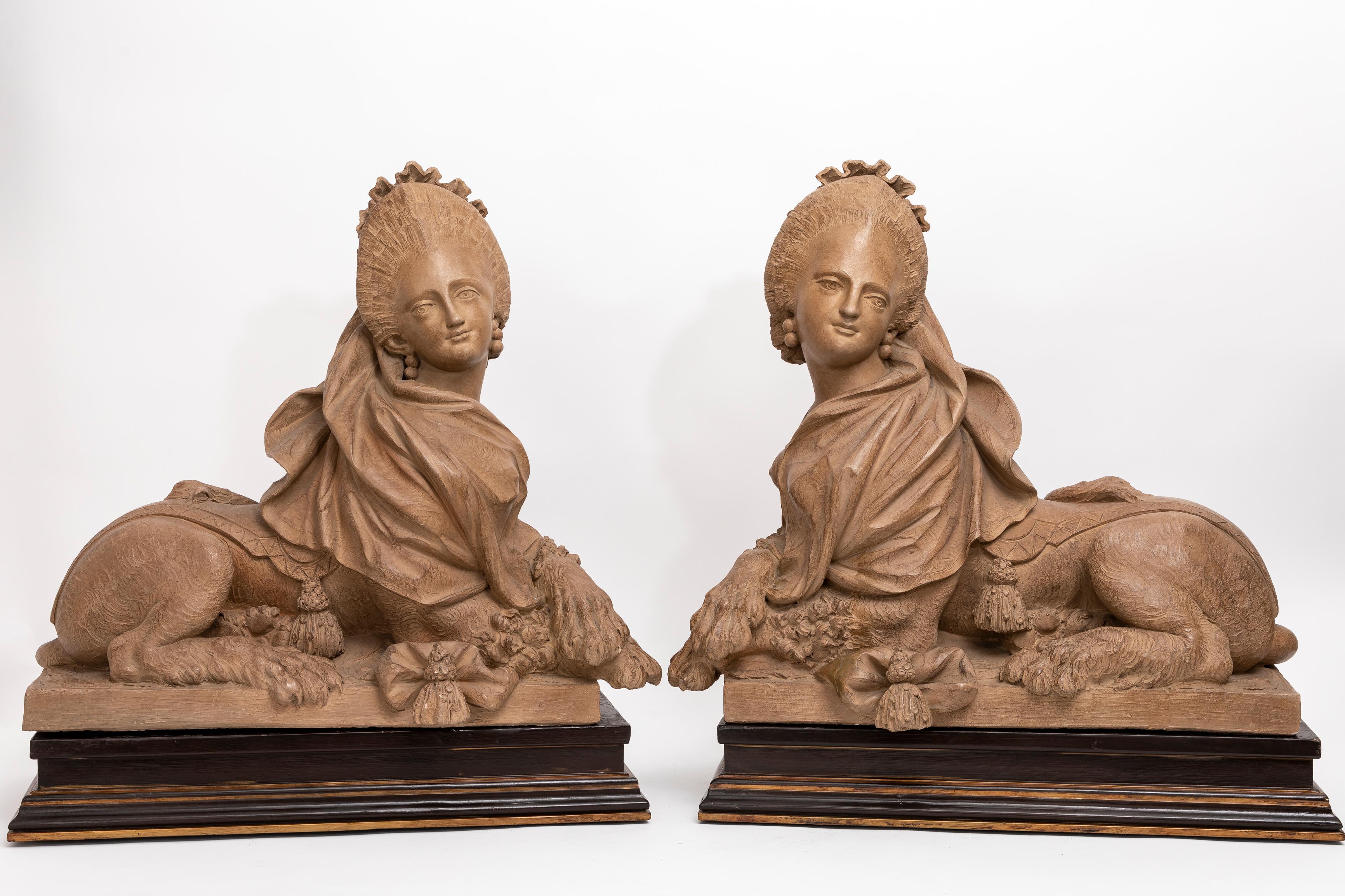 Ein massives Paar französischer Terrakotta-Skulpturen aus dem 19. Jahrhundert, die königliche Sphynxe darstellen und auf Holzsockeln stehen.  Diese beeindruckenden Sphinxen von hervorragender Qualität, die auf einem Holzsockel ruhen, verkörpern die