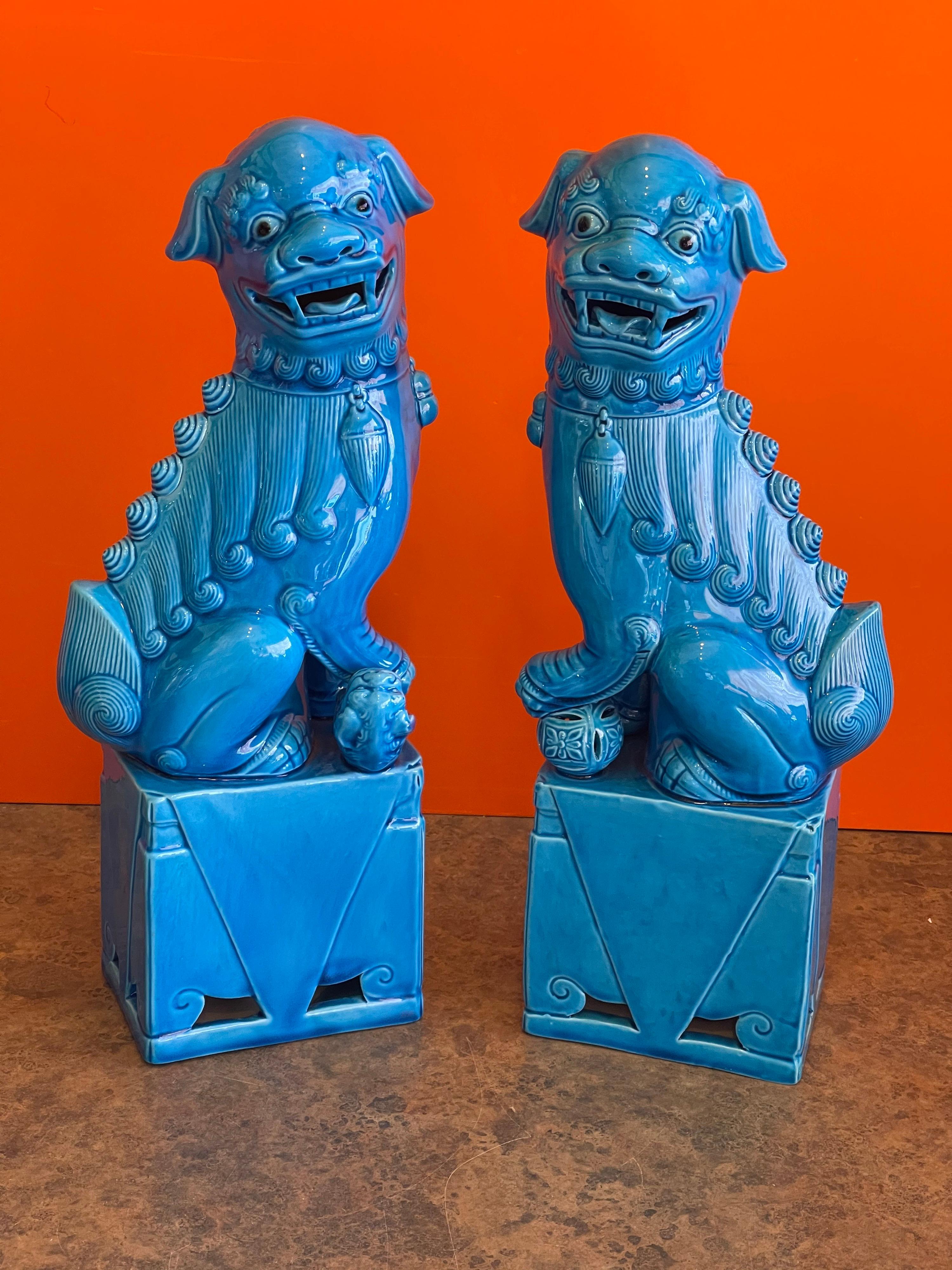 Massive pair of vintage turquoise blue ceramic foo dog sculptures, circa 1960s. These symbolic guardians present a beautiful turquoise hue along with great lines and swirls in the ceramic. 
The pair are in very good condition with no chips, cracks