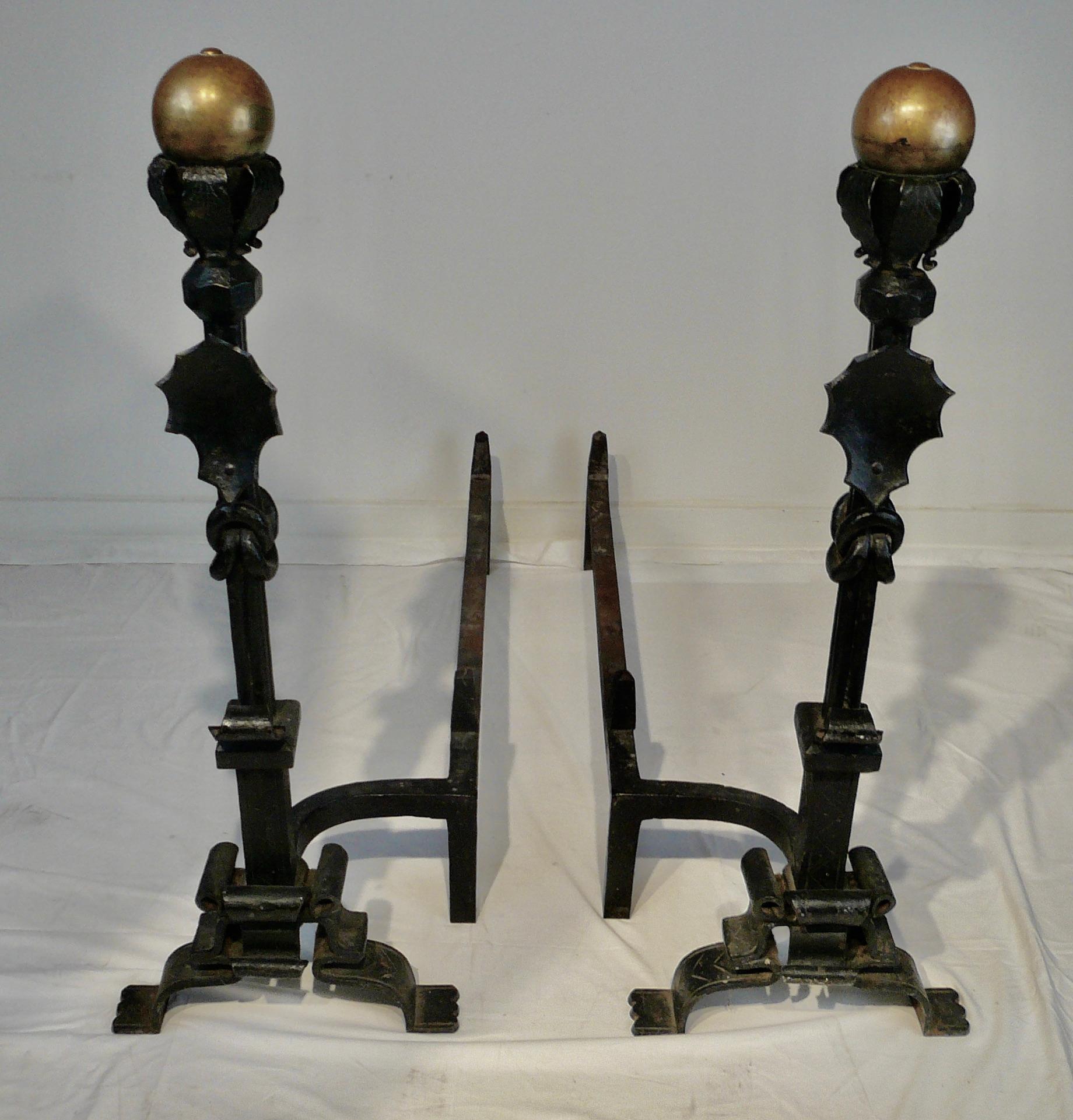 This large and impressive pair of wrought iron and brass andirons are attributed to the famous American maker Samuel Yellin.