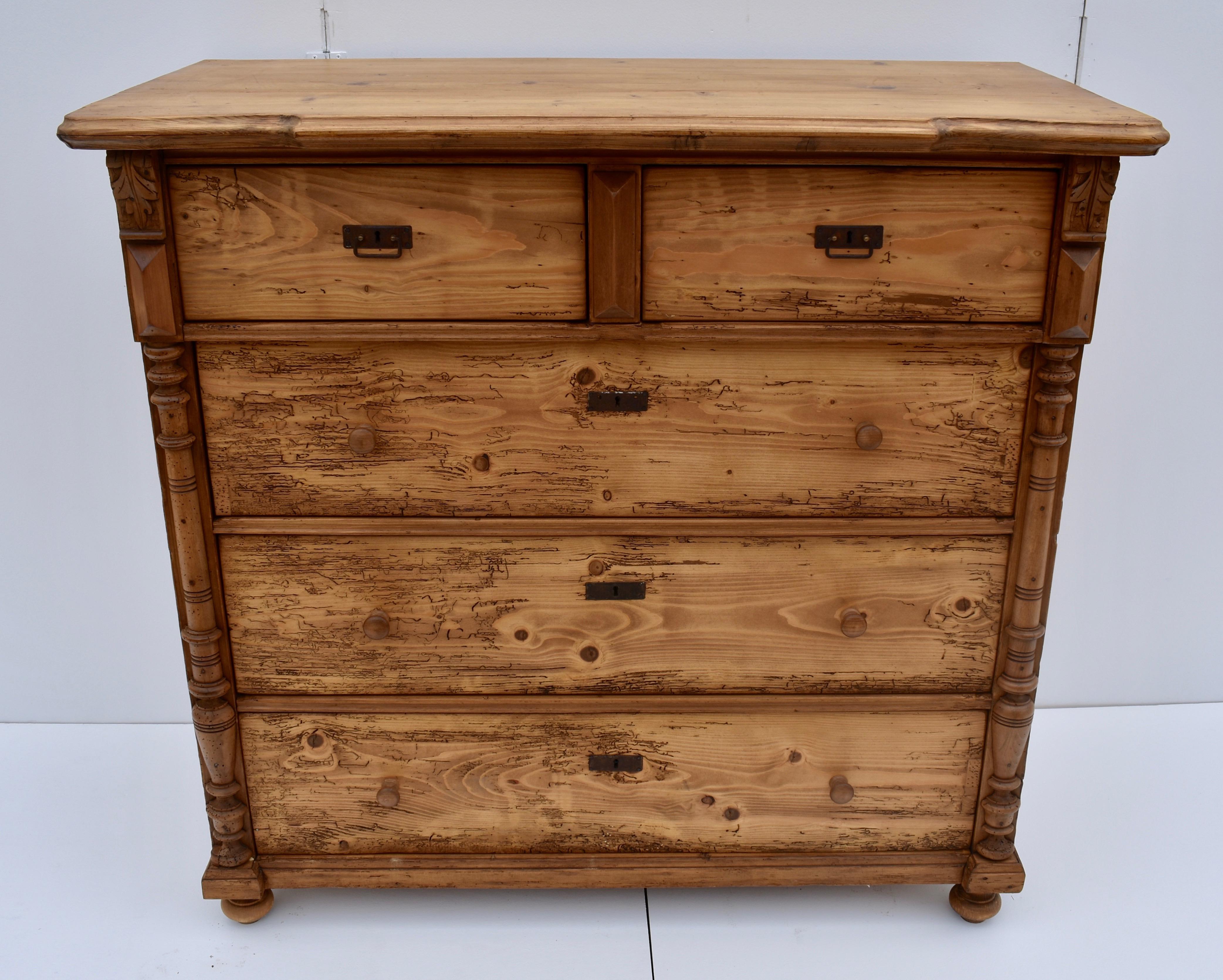 This massive chest of five deep handcut dovetailed drawers has a routed breakfront top, with the two top drawers standing slightly proud of the other three. The front corners are decorated in hardwood with split columns, elongated pyramid moldings,