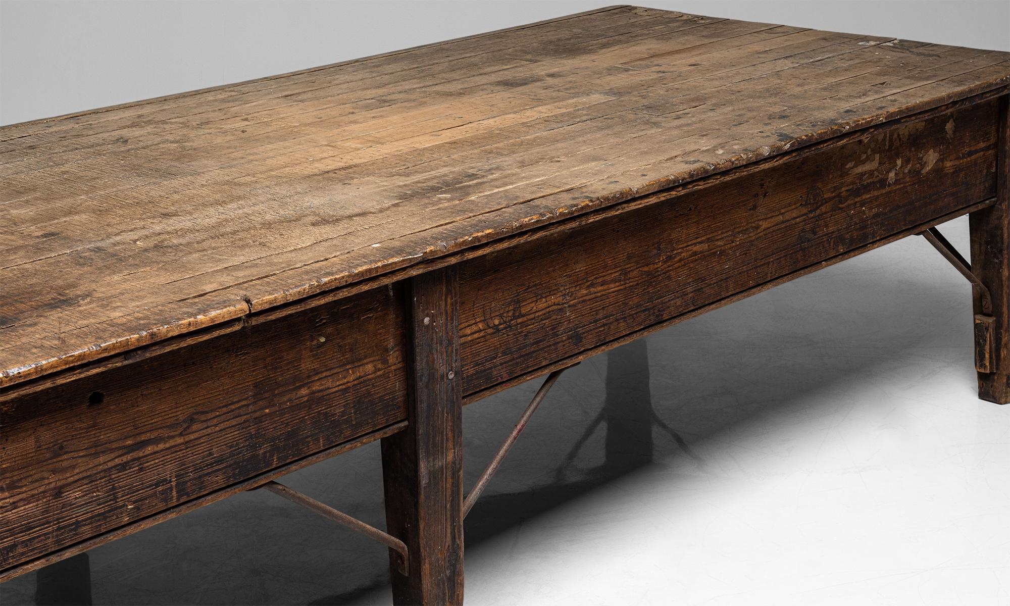 Massive pine mill table
England circa 1900

Pine base with iron bracing and two layer top featuring hardwood tongue-and-groove stips.

Measres: 144.5” W x 51.75” D x 31.5” H.

 