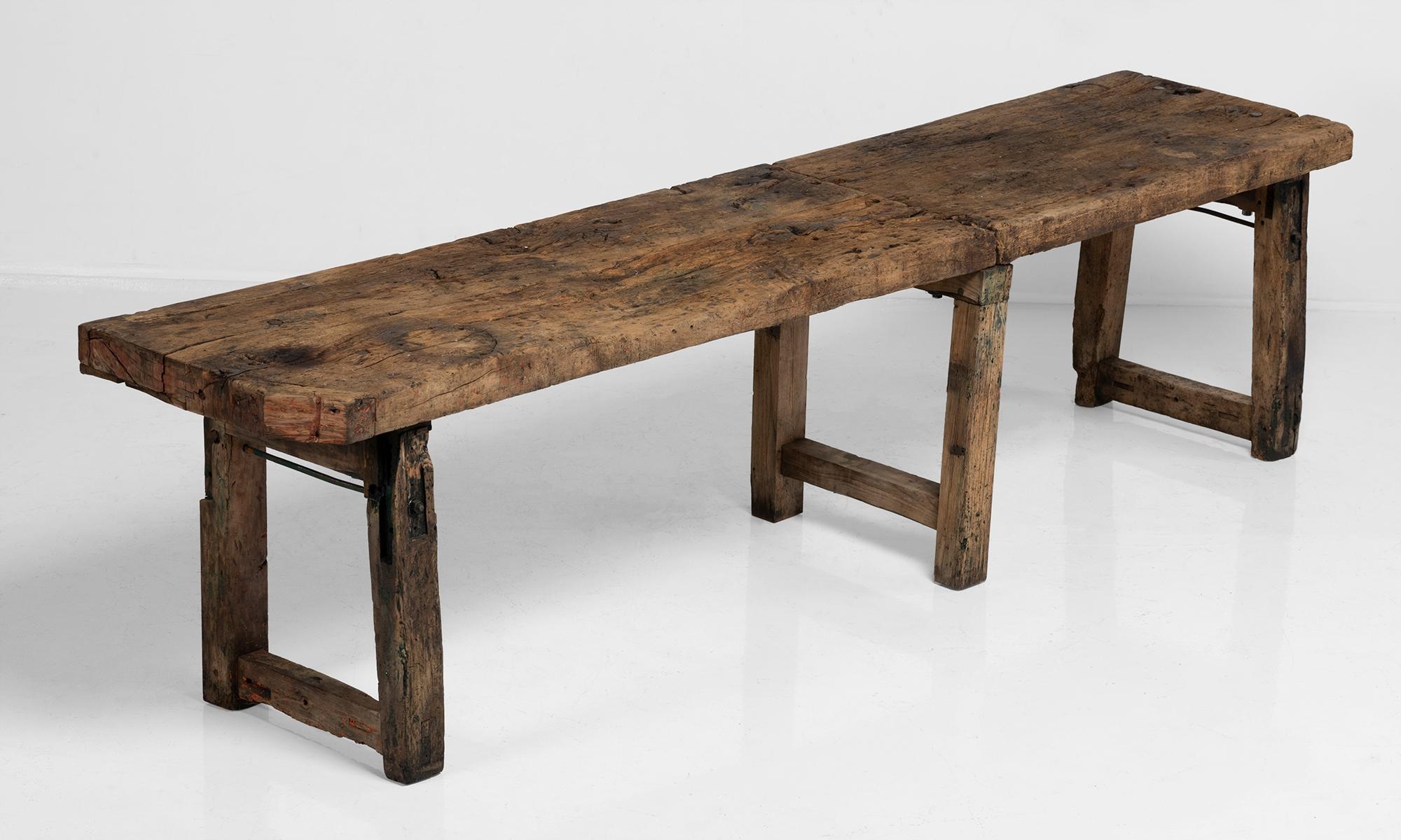 Large work table with thick wooden slabs and iron hardware.