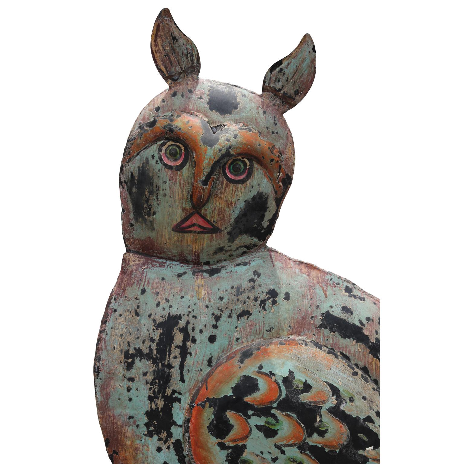 Large scale folk art style tin owl sculpture with a painted patina. Attached to a wooden base to ensure that the sculpture is stable.