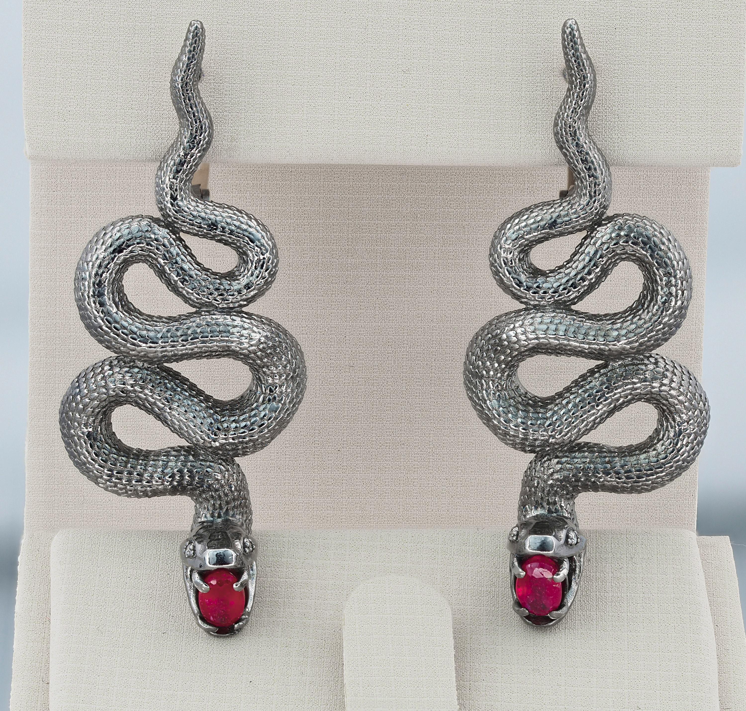 Massive snake earrings.

Metal type: Silver
Total weight: 13.5 g.
Size 42.9 x 17.5 mm.

Central stones: Natural Rubies - 2 pieces
Cut: Oval
Weight: aprx 1.45 ct. total.
Color: Red
Clarity: Transparent with inclusions

Diamonds G-H/VS, rounds