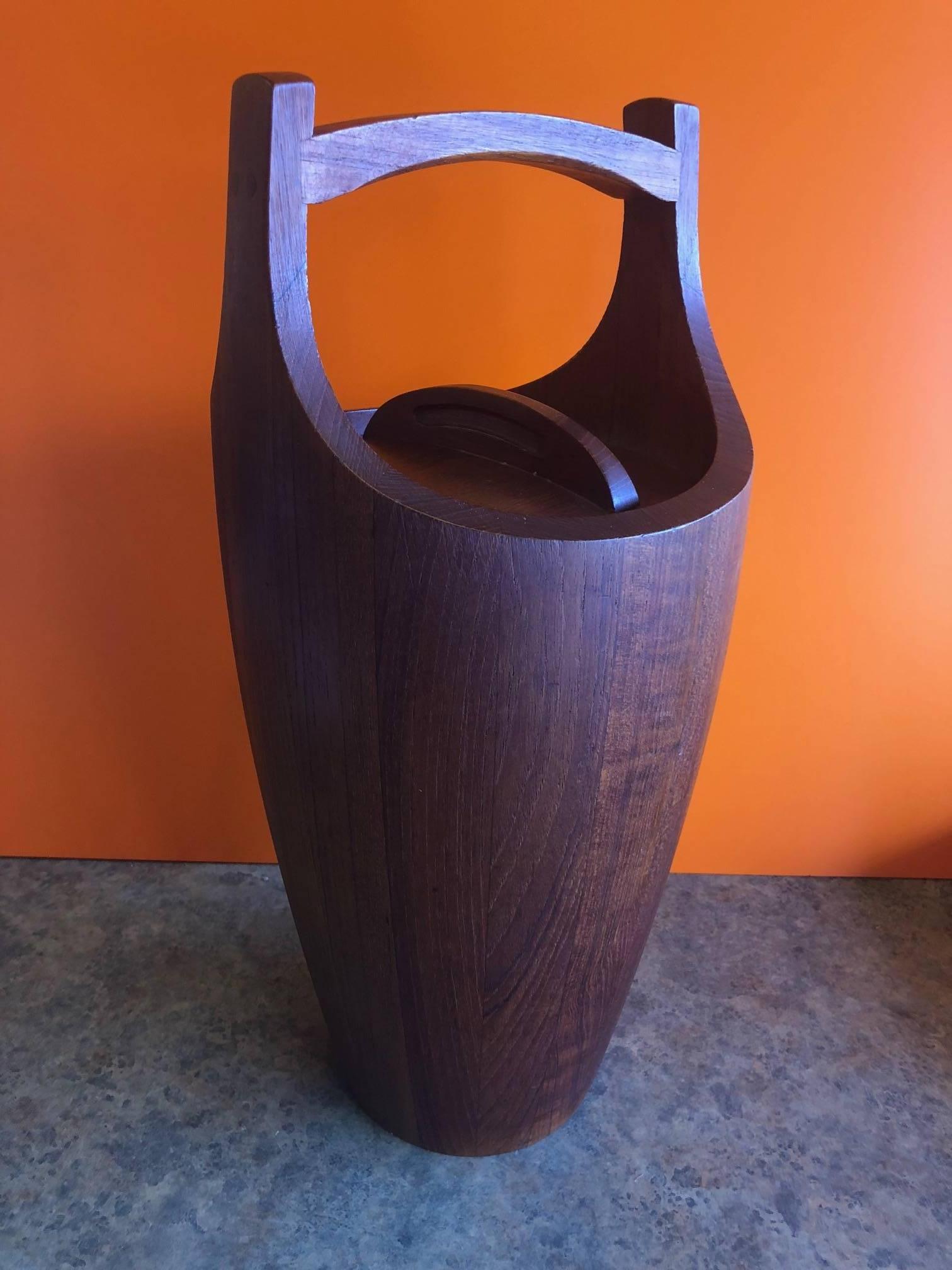Massive staved teak ice bucket by Jens Quistgaard for Dansk, circa 1960s. The piece is in excellent vintage condition with a removable lid and an orange plastic liner.