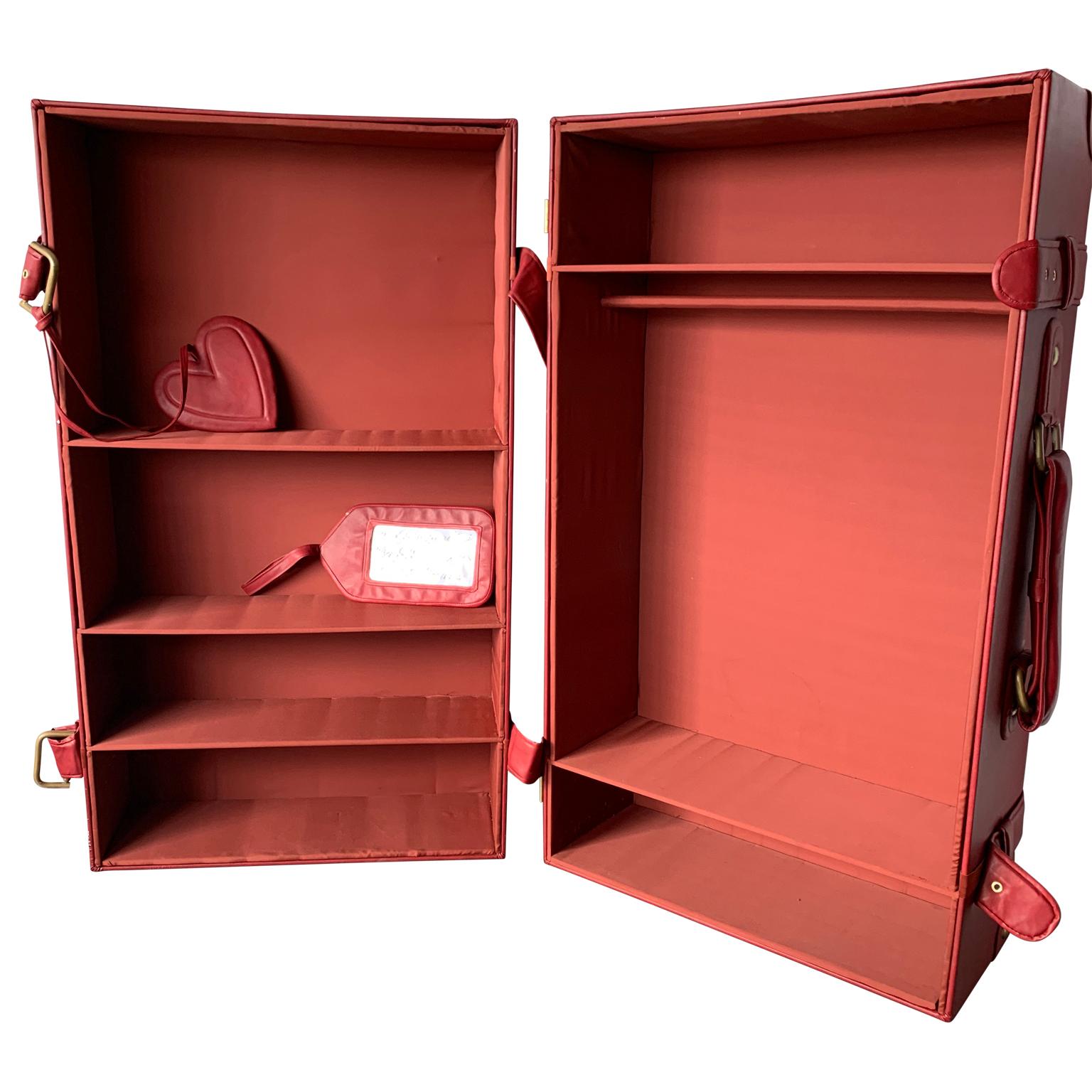Rare vintage suitcase wardrobe in thick red leather by Moschino from their 2013 Milan flagship-store.
Inside walls, coatrack and shelves in upholstered red silk.
Hardware on handles and bracket are made of gilded Lucite, that has some repair to