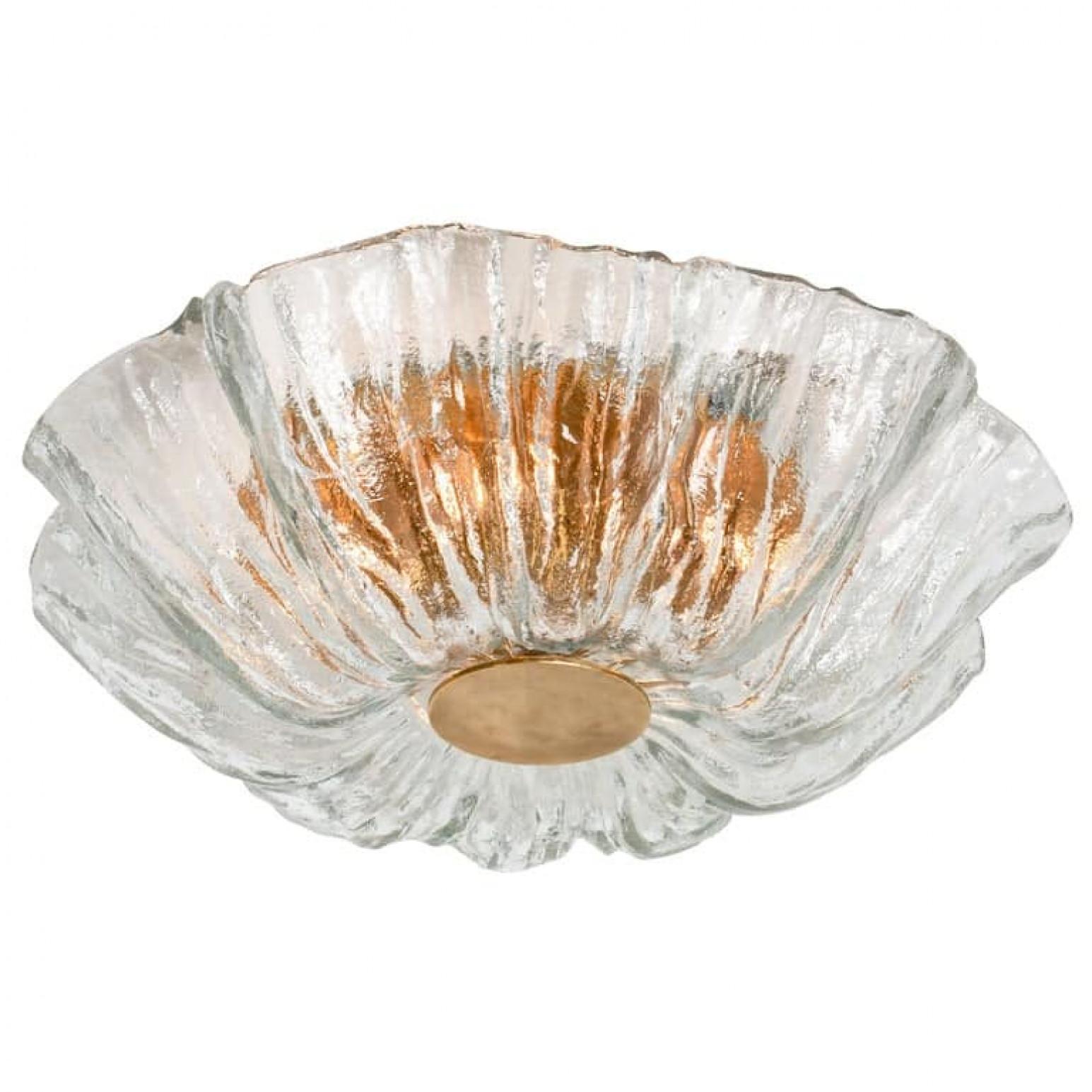 High quality modern textured ice glass flush mounts by Kaiser, circa 1965.
This flush mounts are featuring a huge round hand blown flower glass dish giving the piece a heavy ice appearance which refracts the light, filling a room with a soft, warm