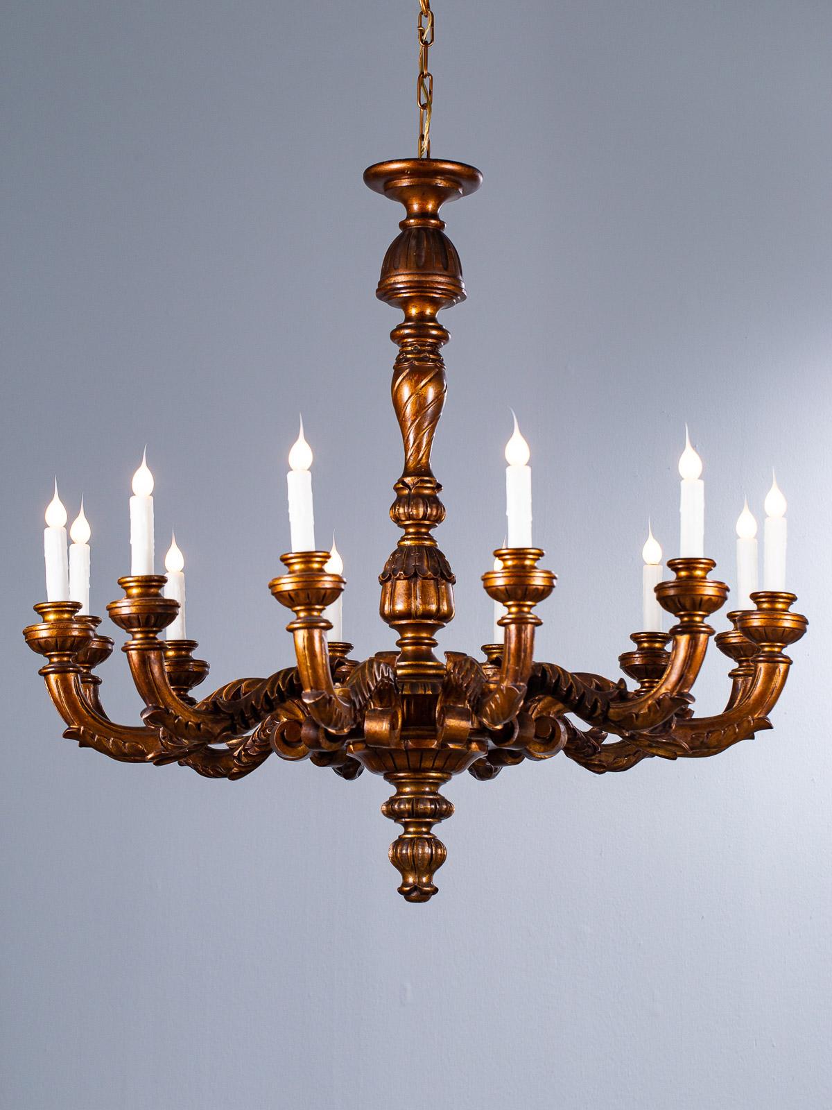 A massive vintage Italian giltwood chandelier circa 1920 having twelve arms. This enormous Italian lighting fixture casts a broad and impressive impression when seen in an interior. The symmetry and balance is perfectly beautiful while the depth of