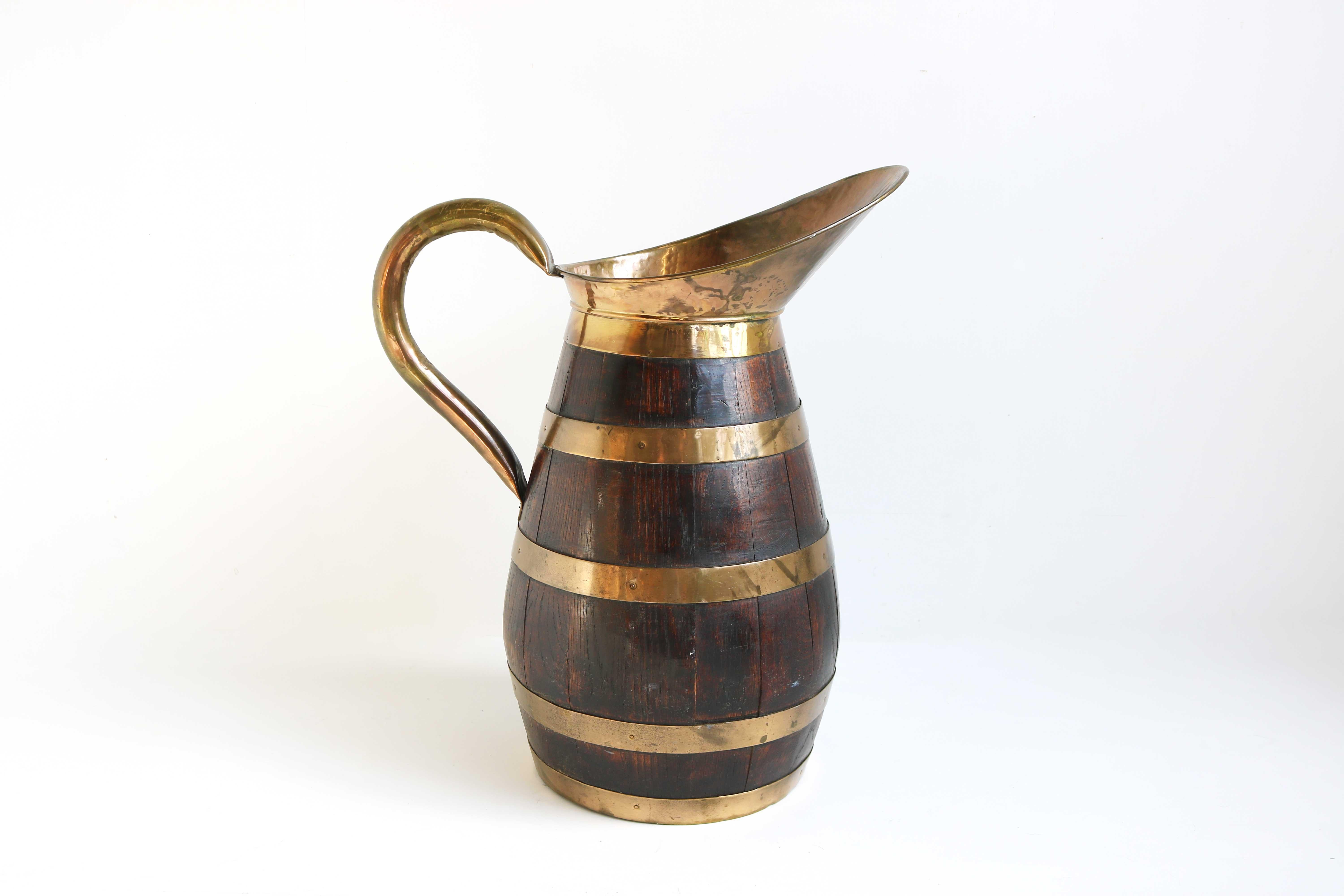 A large 19th century rustic French oak and brass banded handmade cider pitcher , from Normandy
Accessorize your wine cellar , kitchen , dining room or entryway with this antique Water or Wine Jug.
This impressive old pitcher is made of barrel oak