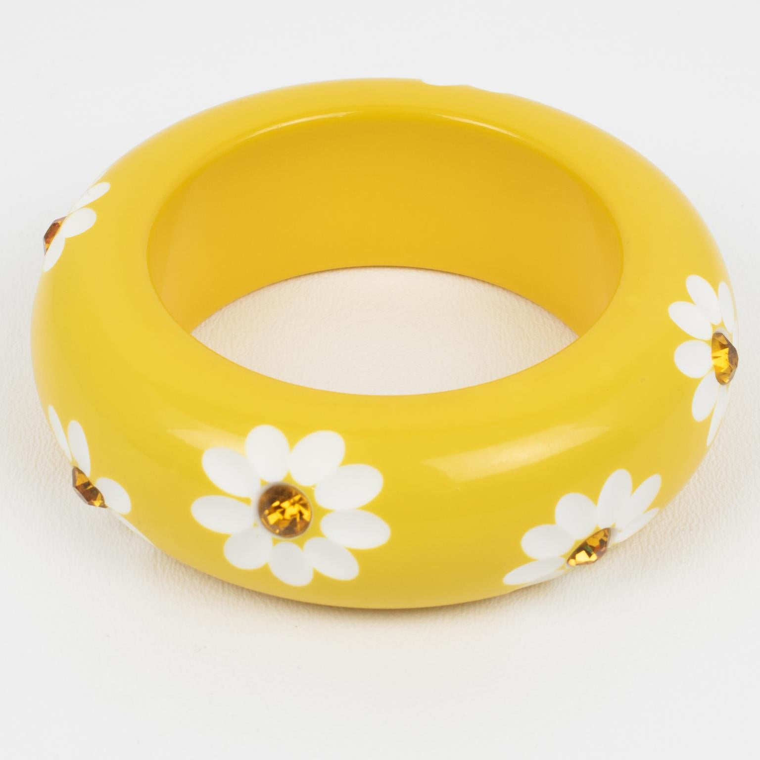 This striking Lucite bracelet bangle features a heavily domed massive shape in a bright yellow color. The bangle is ornate with daisy flowers carved design and orange topaz crystal rhinestones. There is no visible maker's mark.
Measurements: Inside