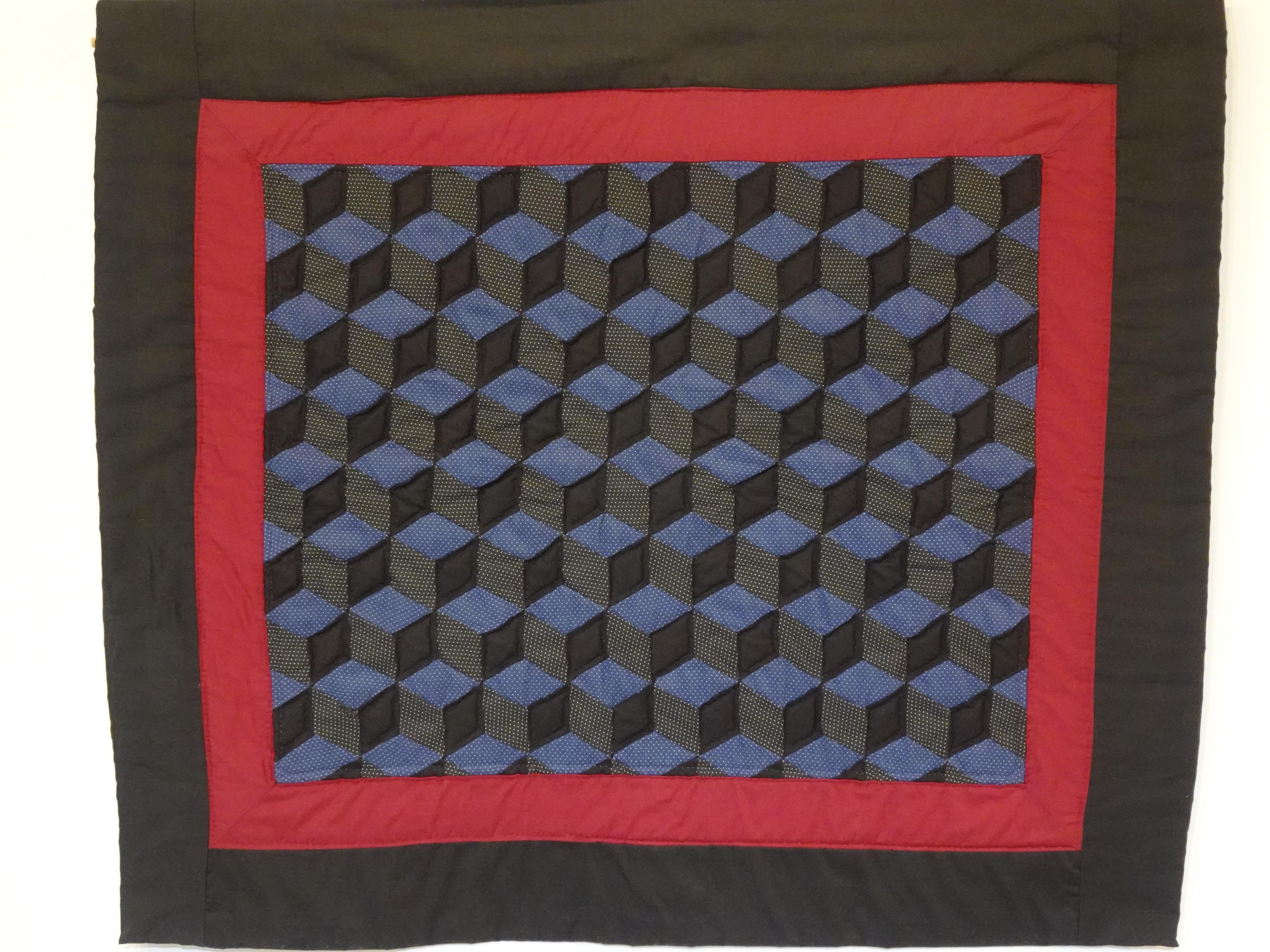 Ein kleiner Wandquilt von Meisterquilterin Nina M. Groves, die für ihren berühmten Quilt-Scheunen-Weg bekannt ist, bei dem Designs von ihr auf über 1000 Scheunen, Gebäuden und anderen Strukturen in 43 Staaten der Welt gemalt wurden. 
 Land. Sie