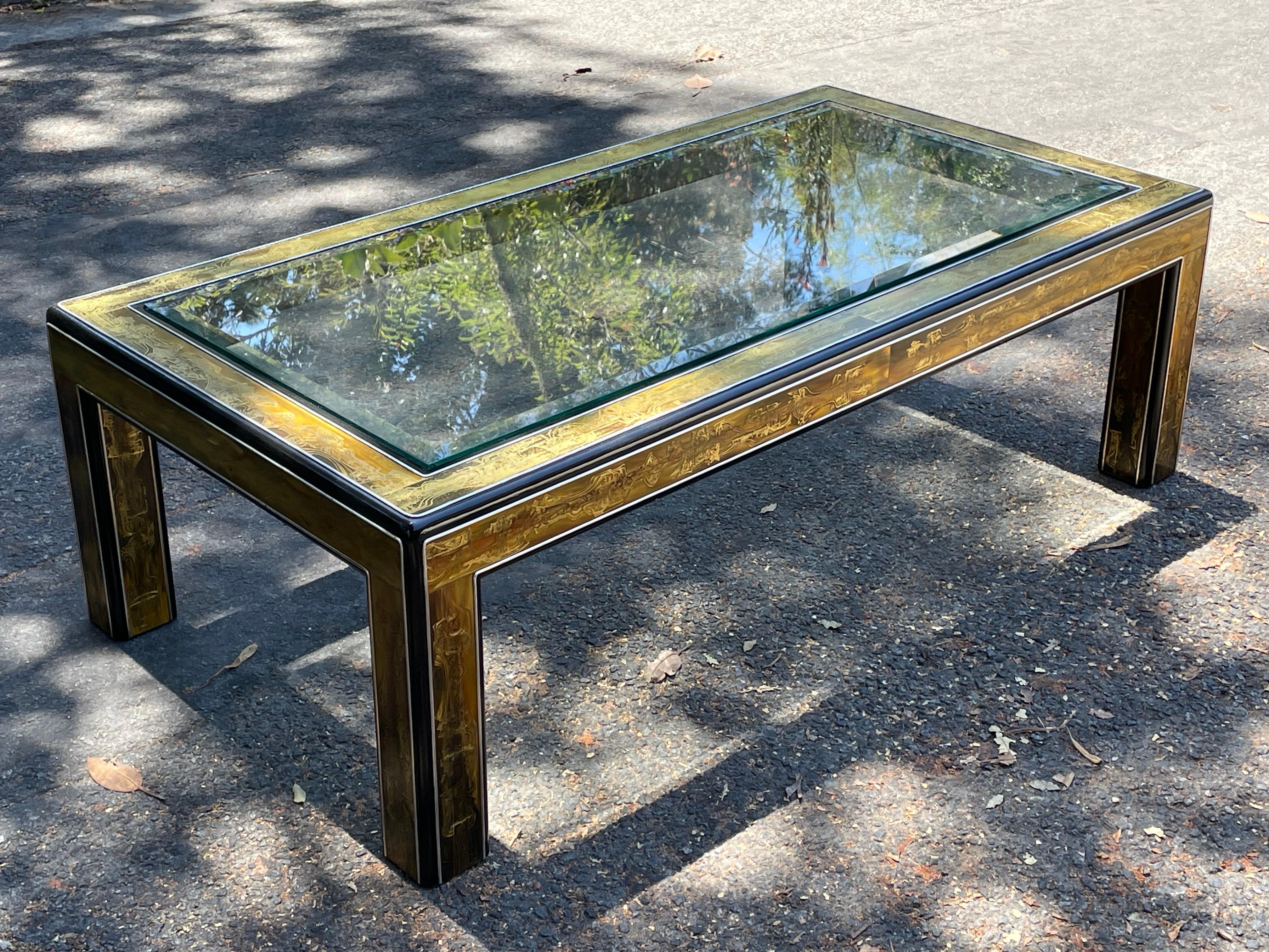 Stunning table by Mastercraft. Features Bernhard Rohne acid etched brass panels with a sleek rounded black lacquered edge.

The base is in very good vintage condition. As is the glass. Gorgeous table. 

We currently have this paired with Milo