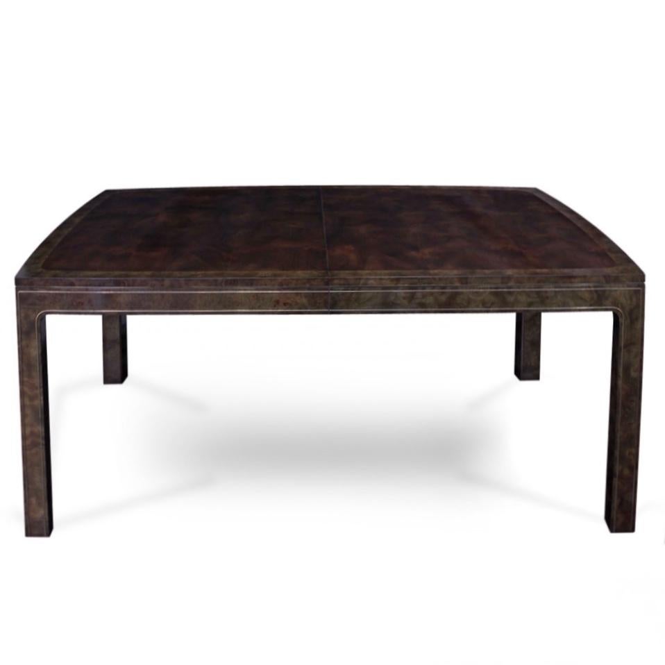 Designed by William Doezema, this refined model 869 dining table by Mastercraft features burl amboyna wood with brass trim details. With the installation of three 20