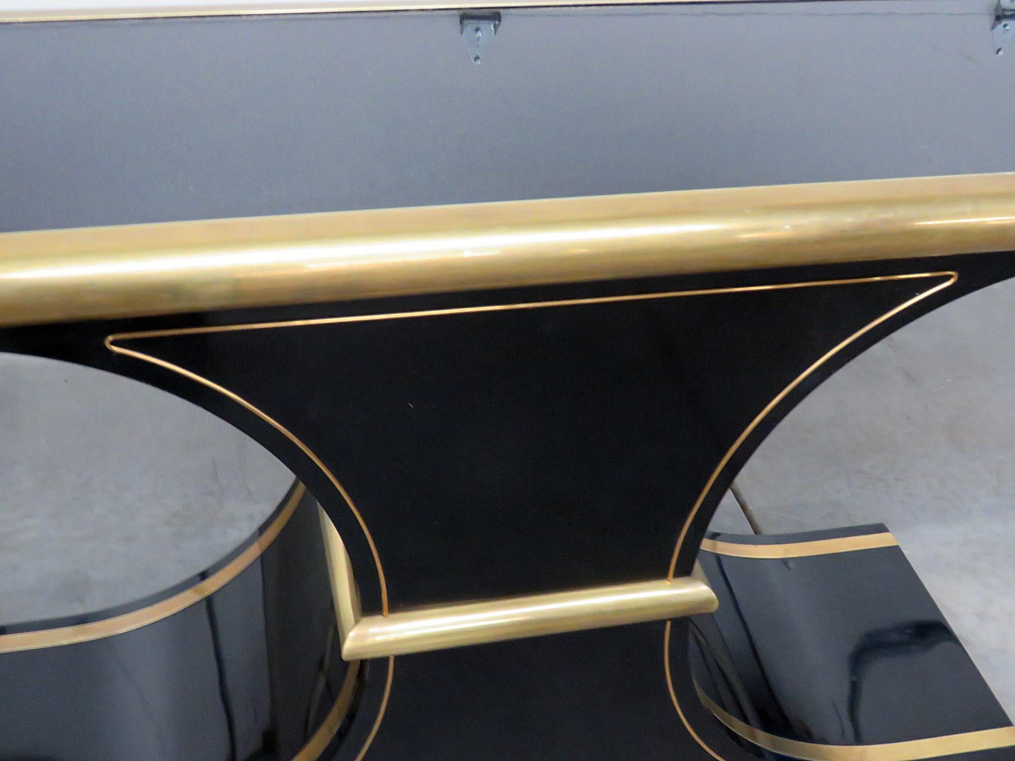 Mastercraft Art Deco black glass console table with brass trim.