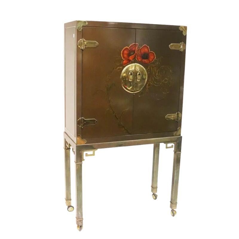 A vintage Mastercraft Asian style two door cabinet, perfect for a bar.  The lacquered body is fitted with Chinosierie style brass hardware and decorated with a beautiful red poppy above the round brass door handle.  Inside the doors open to a