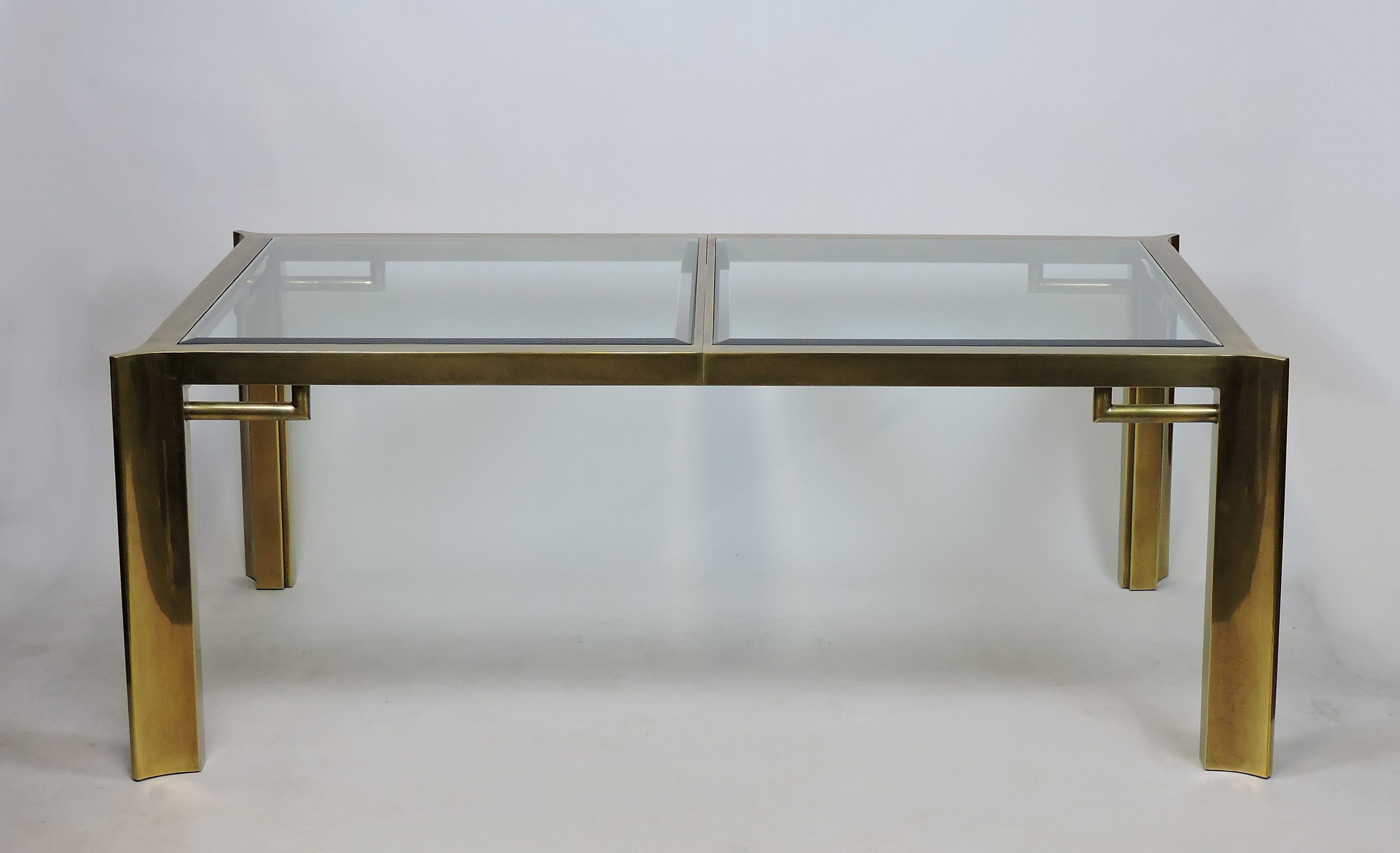 Impressive and elegant Mastercraft dining table. This table is made of solid brass with heavy beveled clear glass inserts and was designed by the co-founder of Mastercraft, William Doezma. When the leaf is installed, the table extends to a very