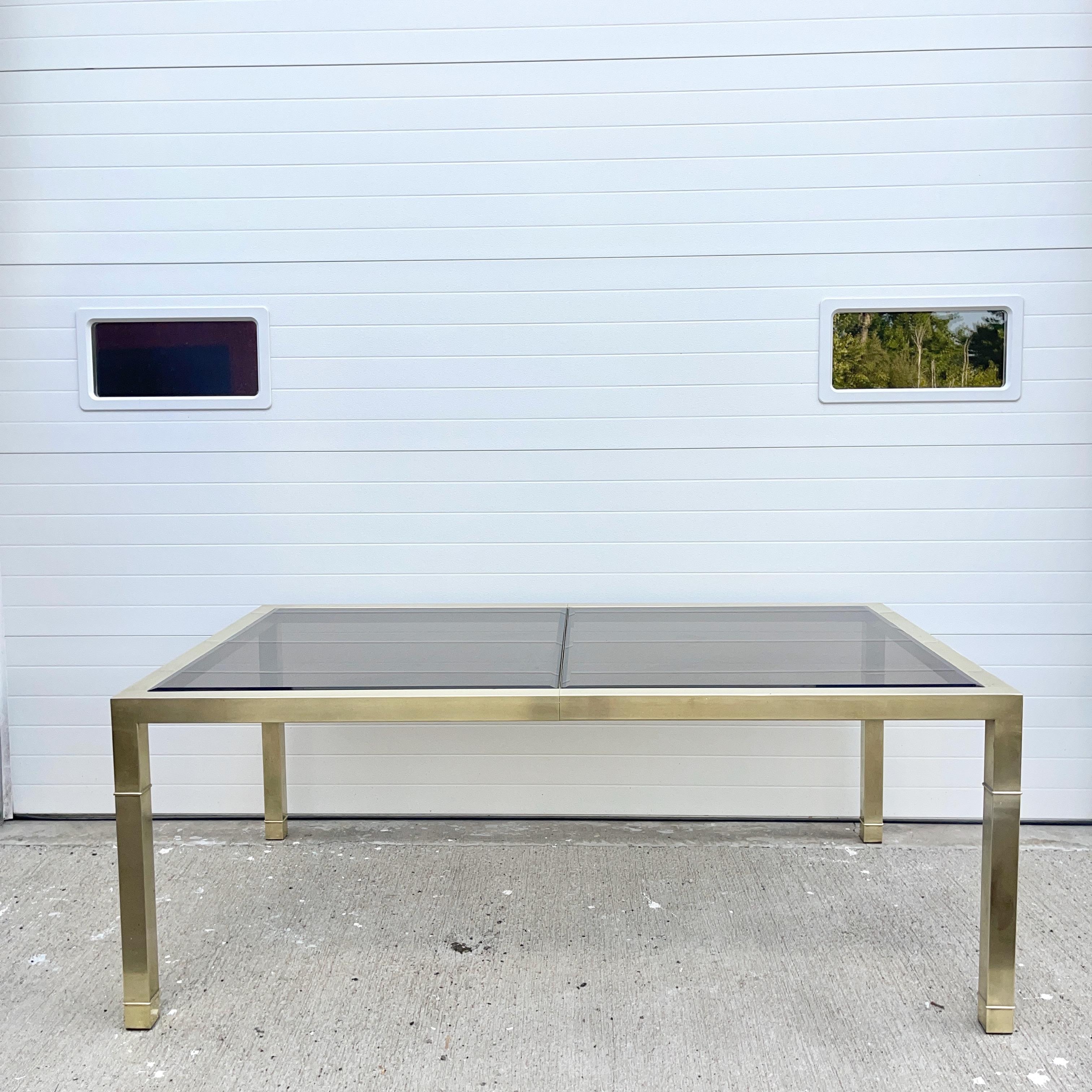 Vintage 1970's Mastercraft of Grand Rapids extendable brass dining table with bronze tinted and beveled glass inset tops.
Table is 29.5 inches high by 44 inched deep. Without the single 24 inch leaf the table is 76 inches long. 100 inches fully
