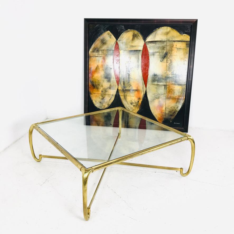 Tubular brass frame with a cross stretcher base and glass top. 1970s.