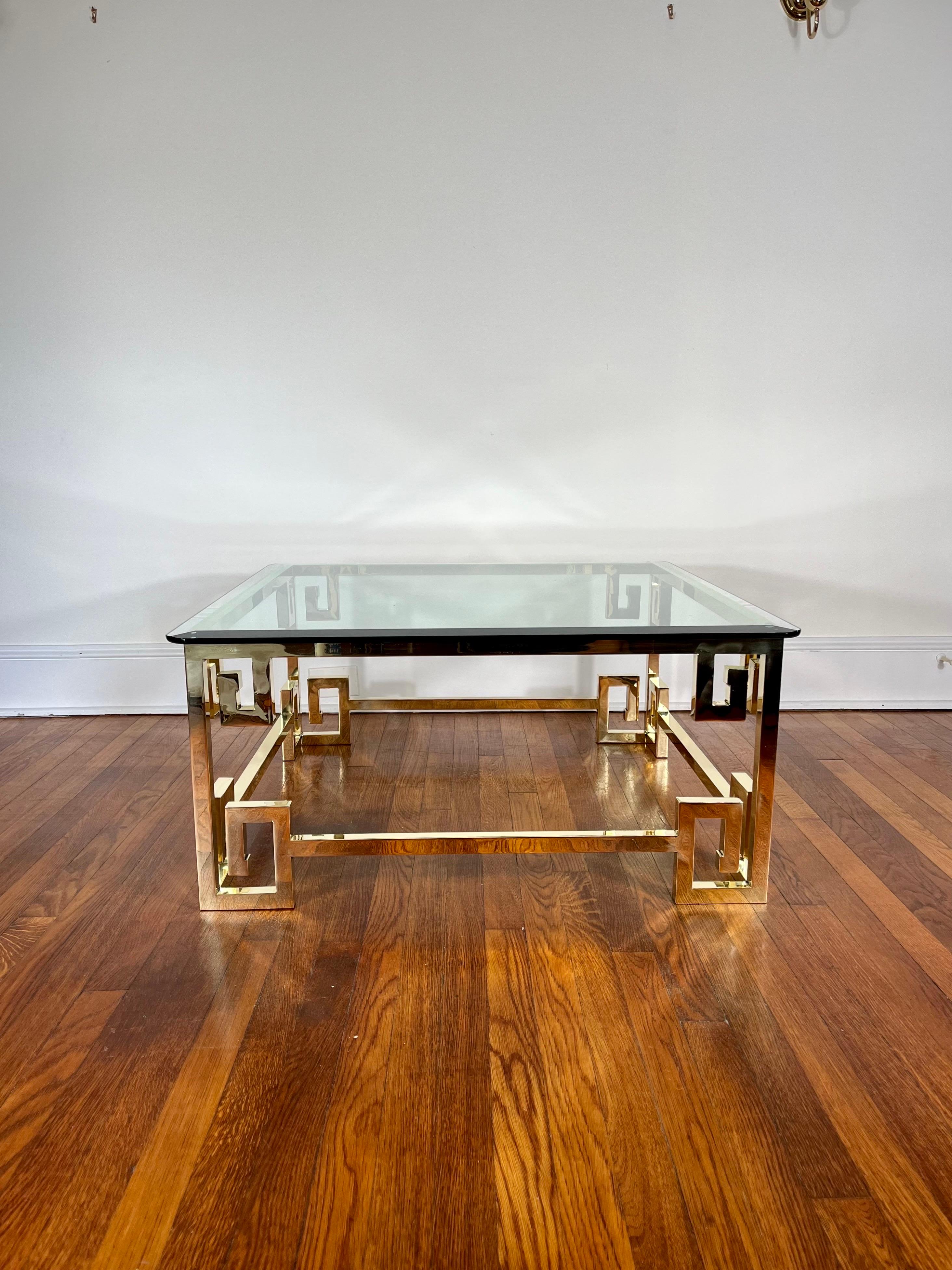 Beautiful and classic style in this brass and glass coffee table by Mastercraft. Greek Key detail throughout. Thick beveled glass top(36x36). Stunning recently polished to a high gloss live finish which will patina over time. 
Curbside to NYC/Philly
