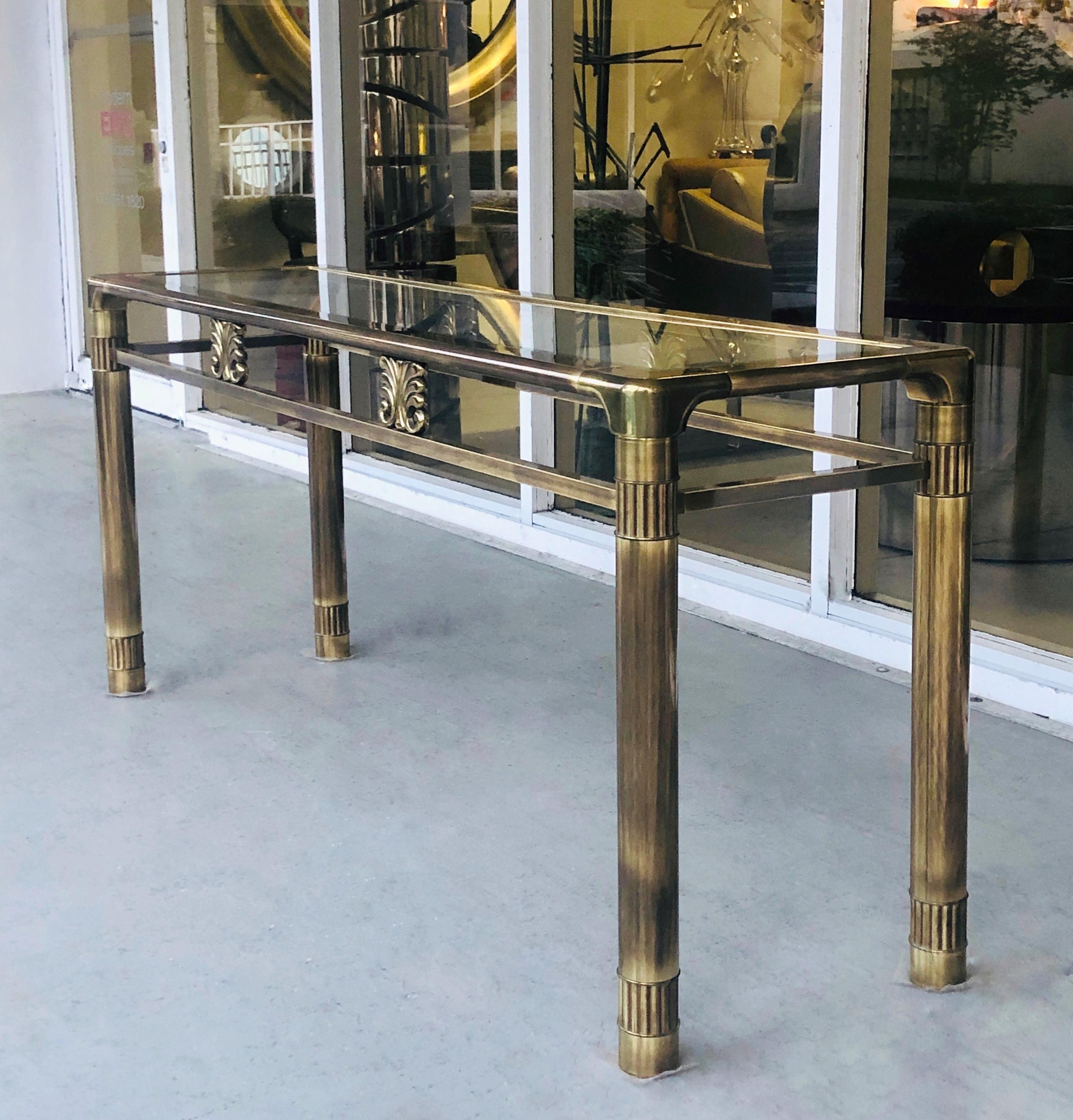 A Mastercraft brass console table. Retains the original beveled glass top and rich patina.